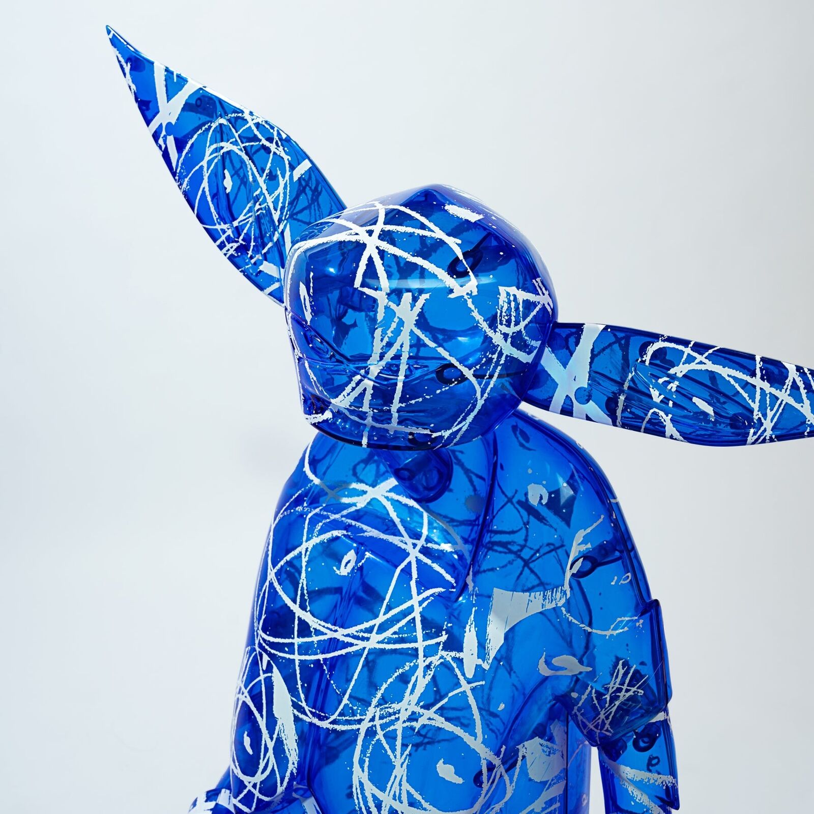 A blue and white sculpture of a man with a hat on his head.