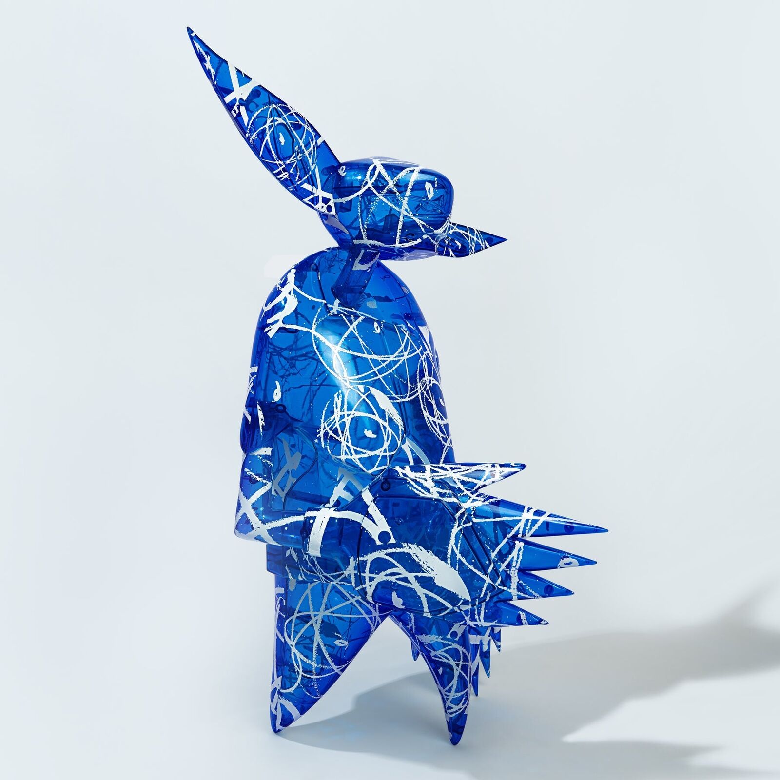 A blue and white sculpture of a man with a hat on his head.