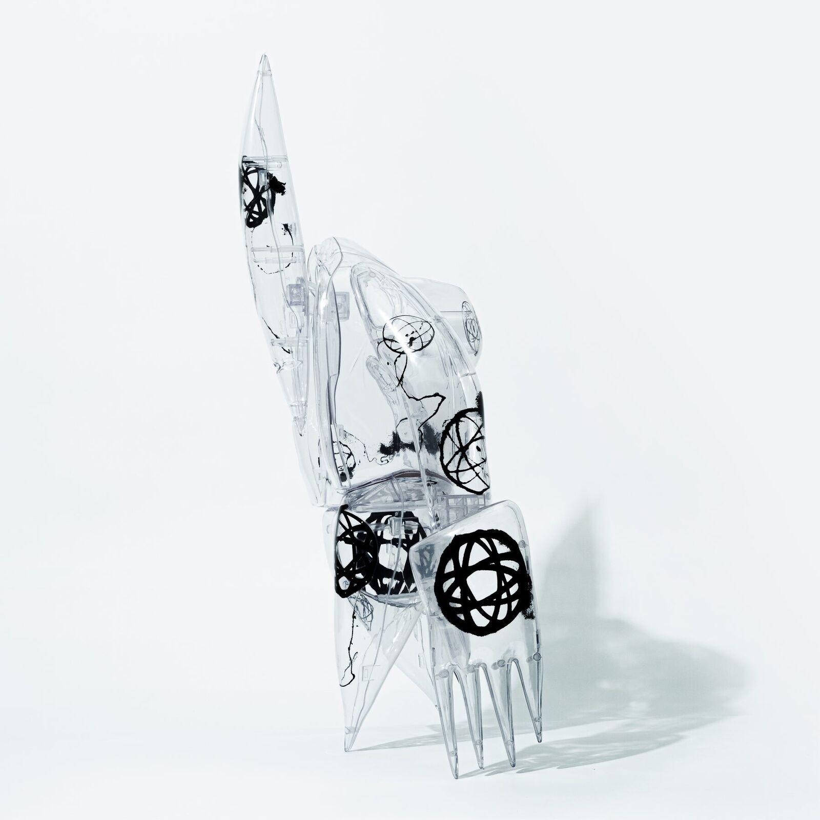 A clear plastic robot with a black and white design on it.