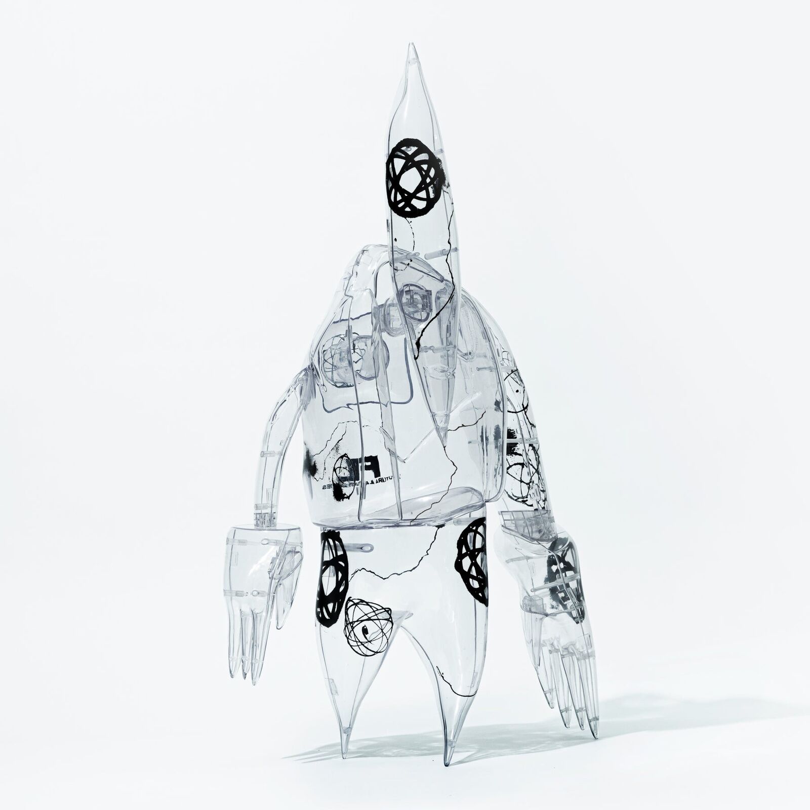 A clear plastic robot with a black and white design on it.