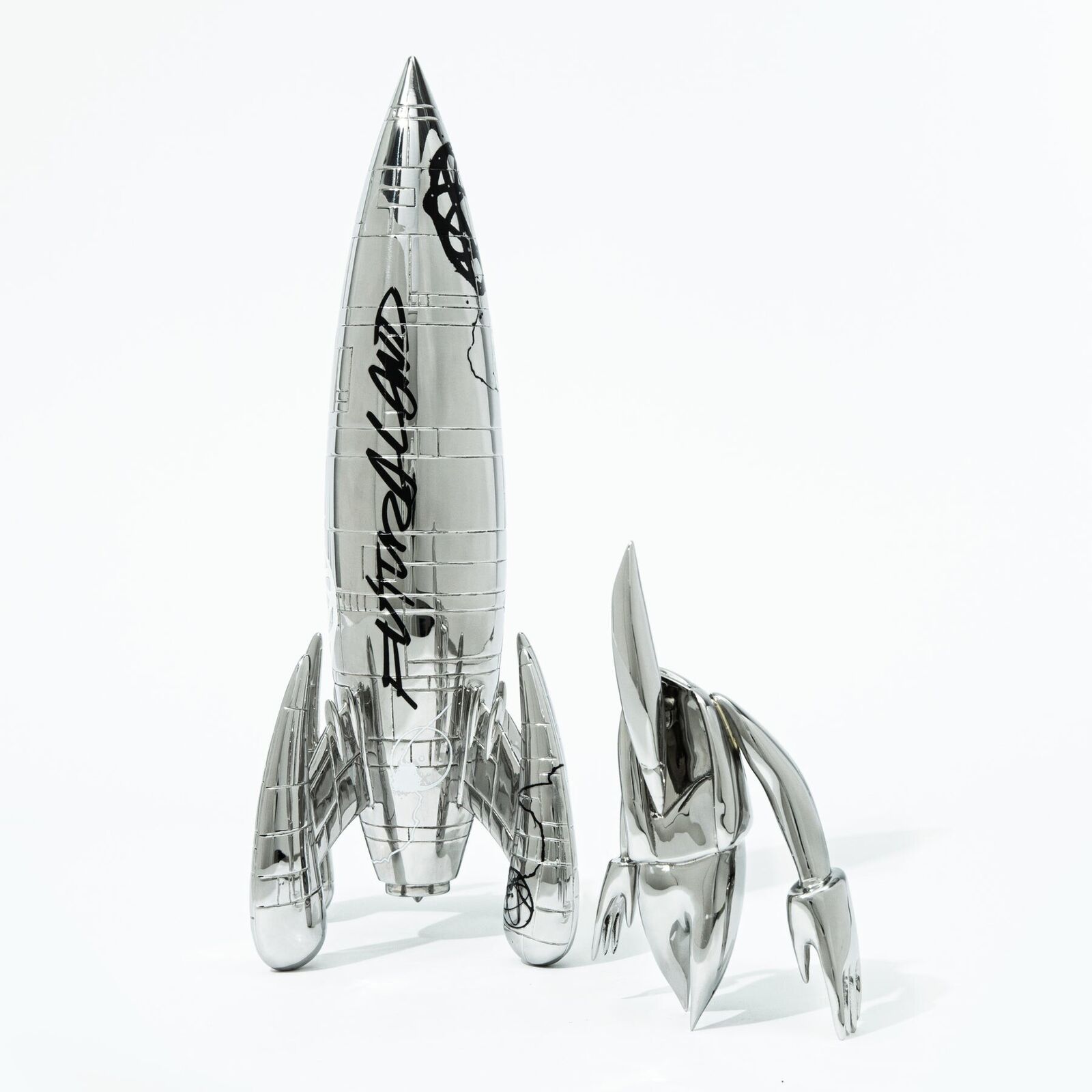 A silver model of a rocket ship with a black and white design.