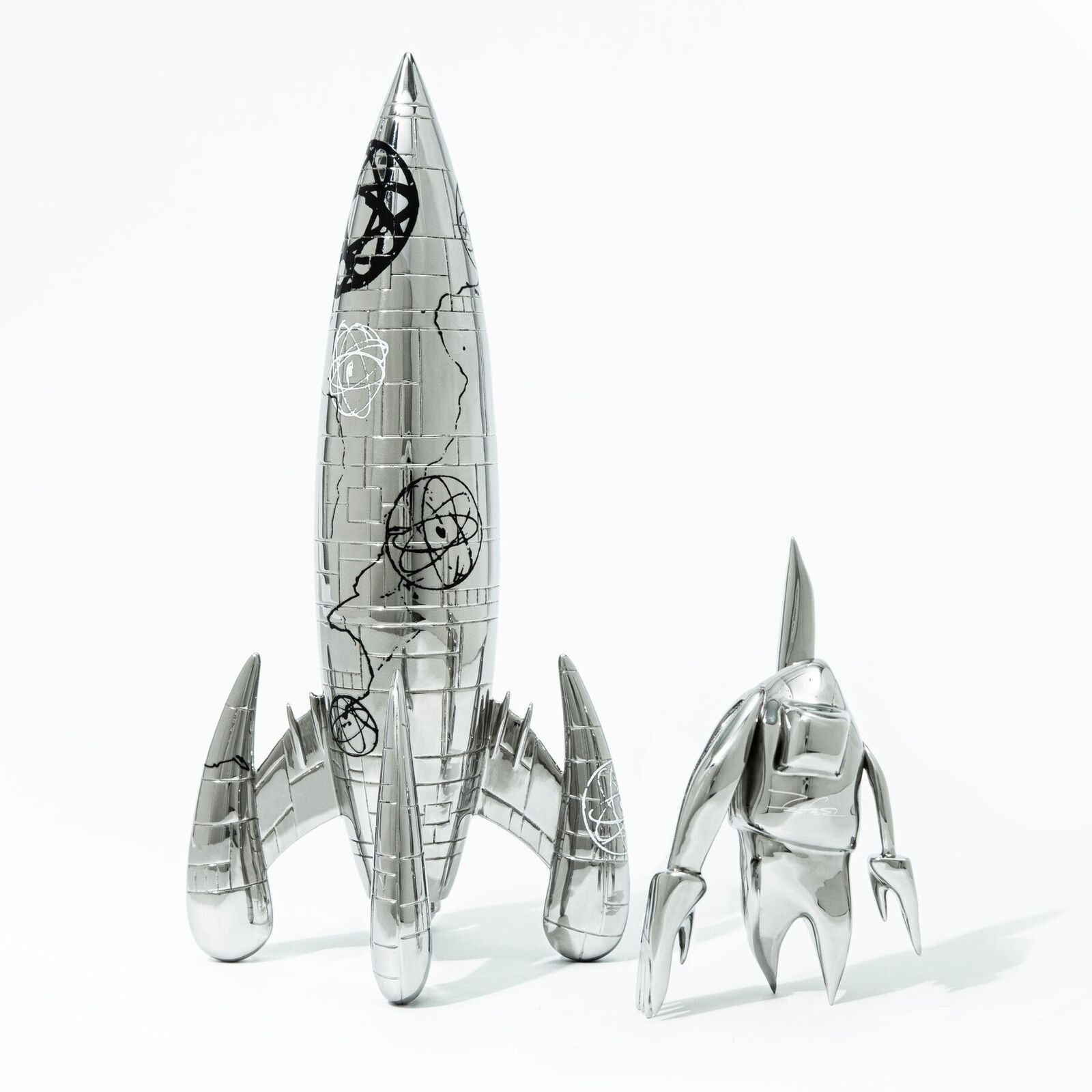A silver model of a rocket ship with a black and white design.