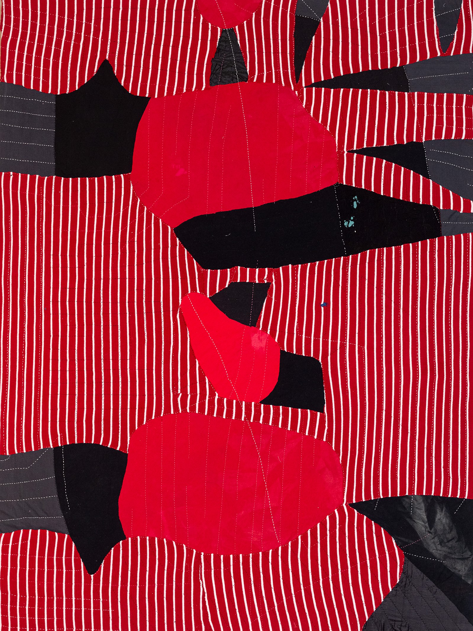 A red and black quilt with black and white stripes.
