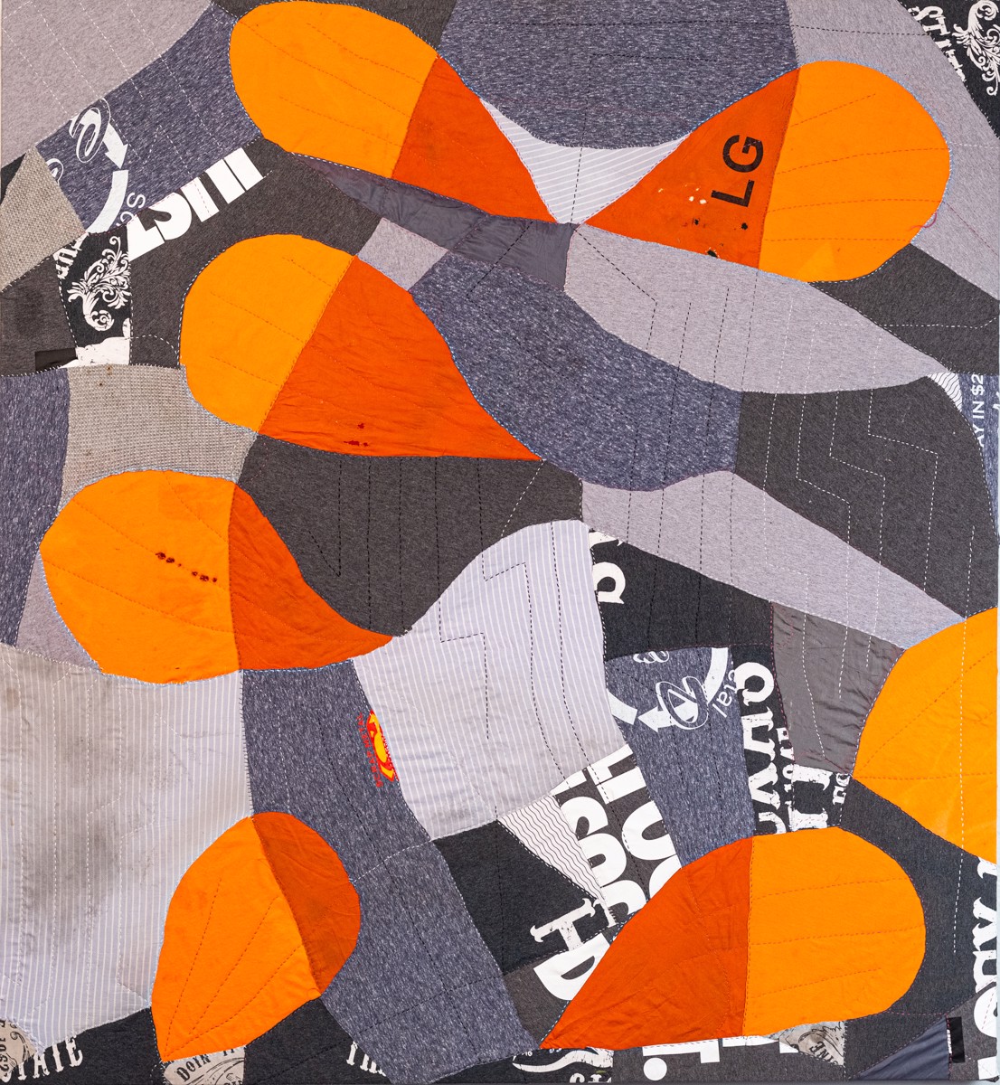 A close up of a quilted piece of art on a table.