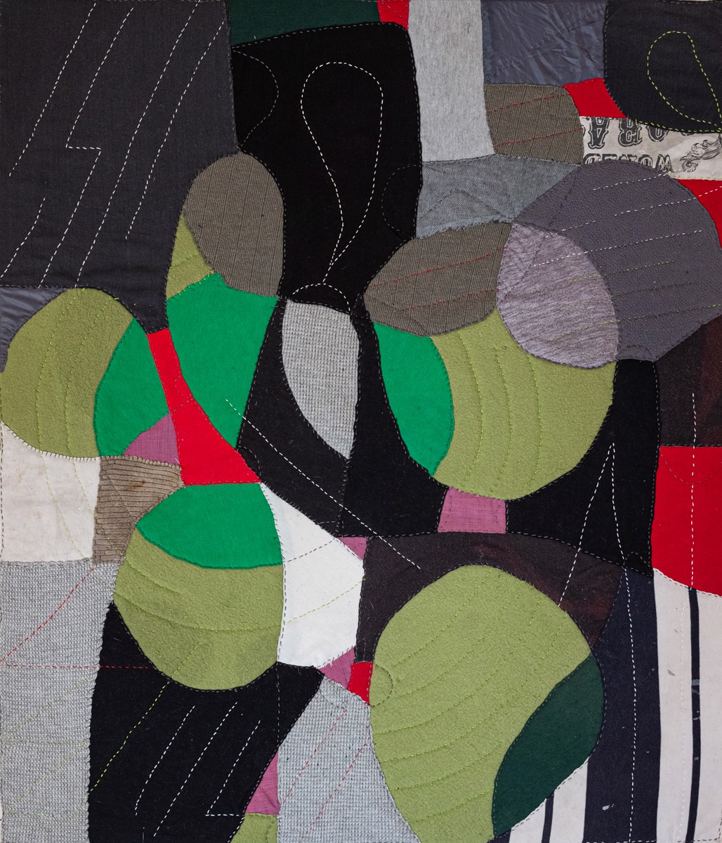 A close up of a quilted wall hanging on a wall.