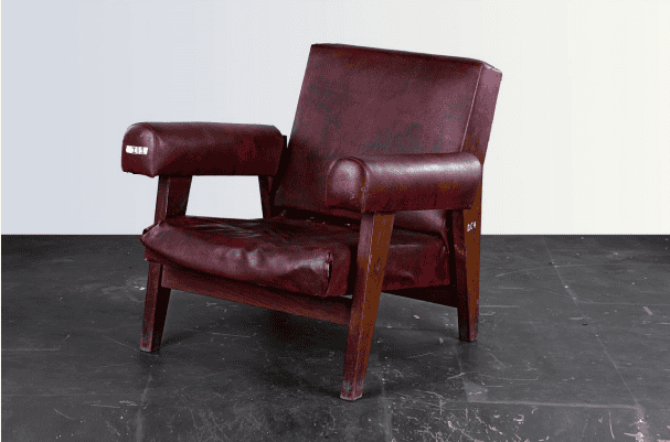 A vintage-style armchair with deep red upholstery and wooden frame against a minimalist background.