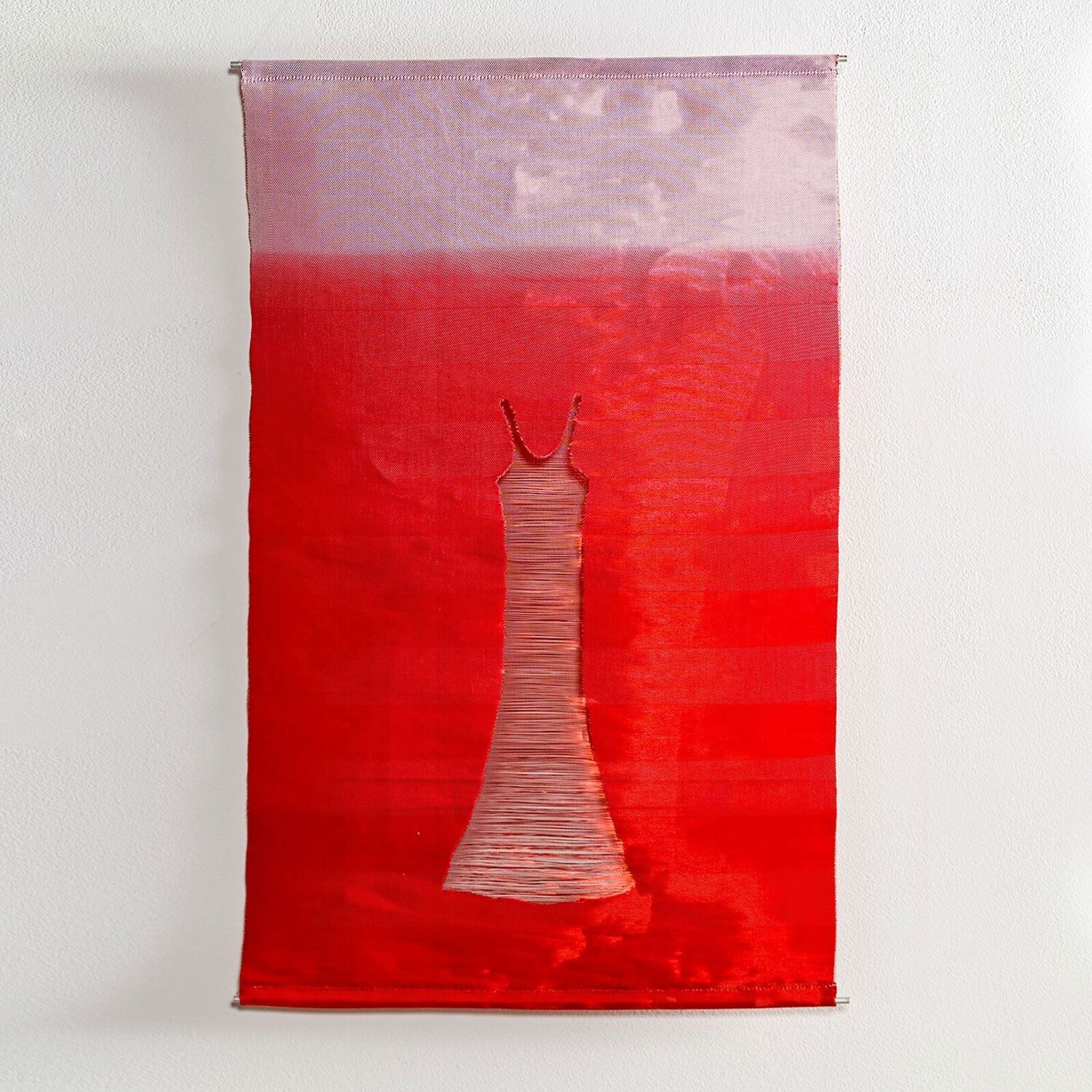 A red and white painting of a dress hanging on a wall.