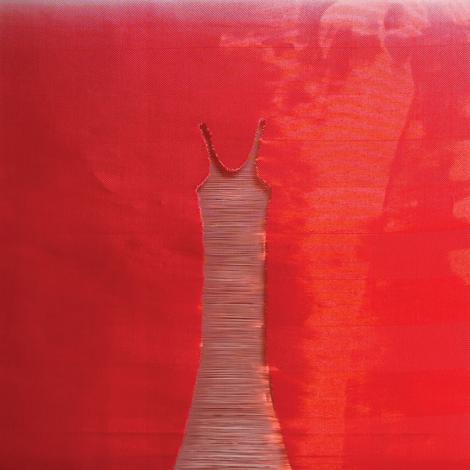 A red and white painting of a dress hanging on a wall.