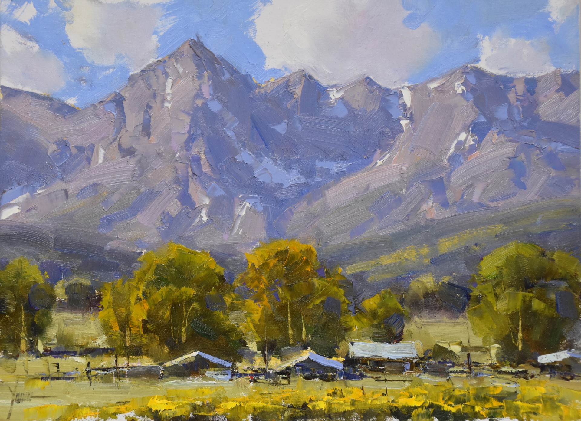 A vibrant landscape painting of a village nestled at the foot of towering mountains.