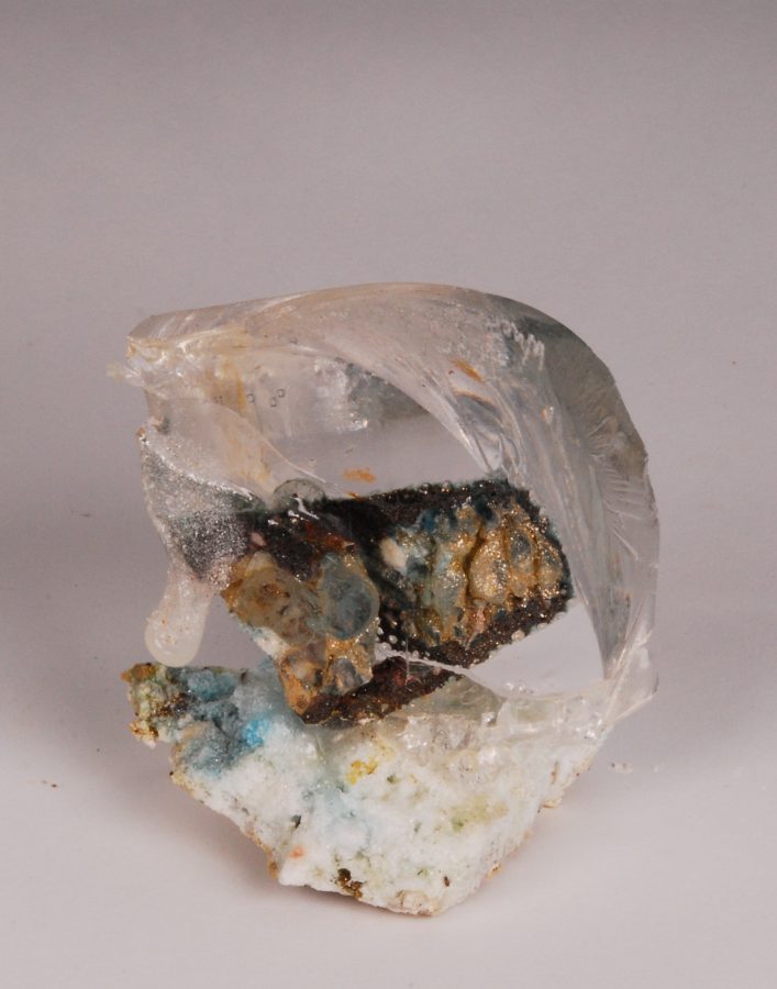 A translucent, glass-like sculpture encasing a rough, mineralized core.