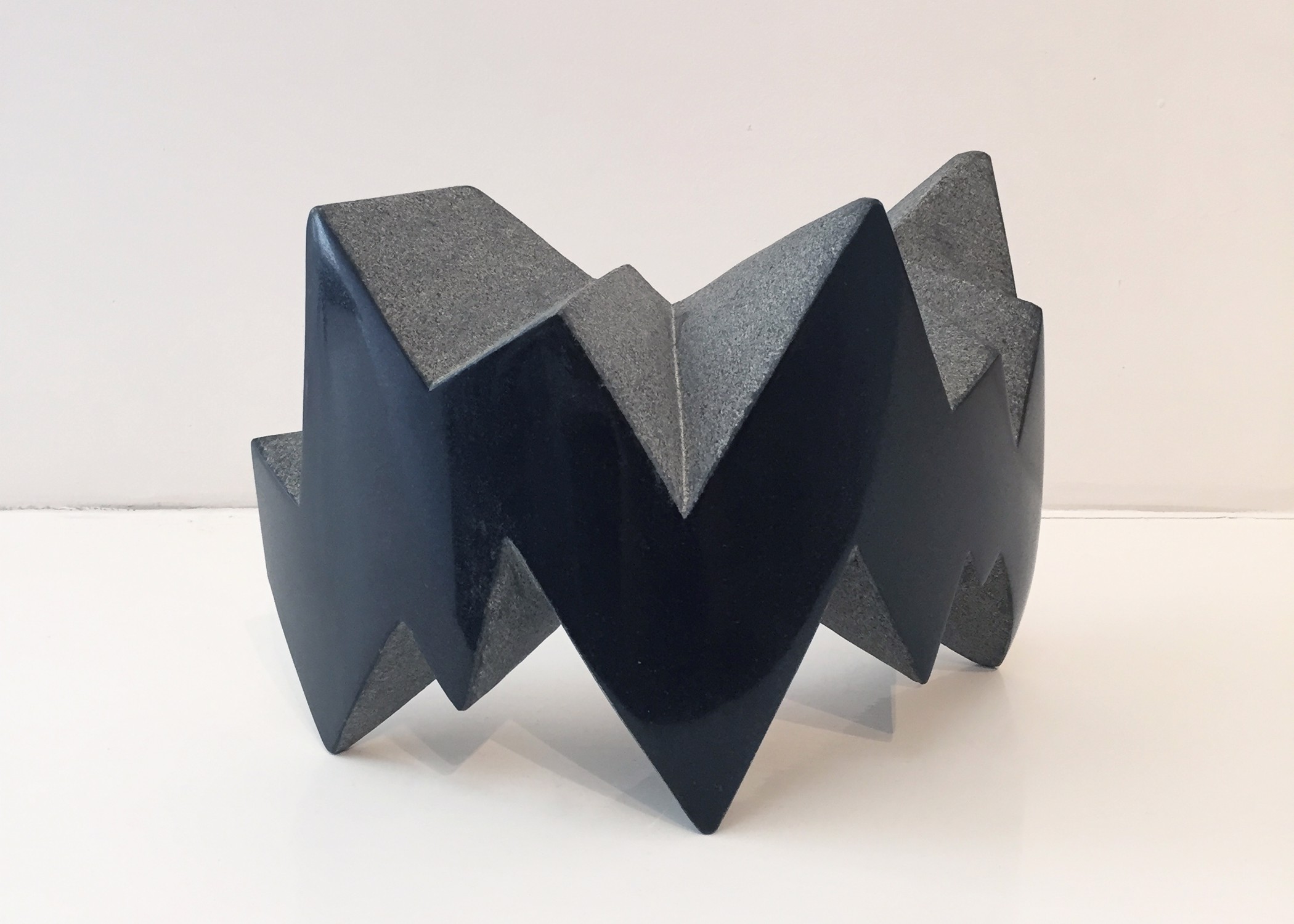 A black and gray sculpture on a white surface.