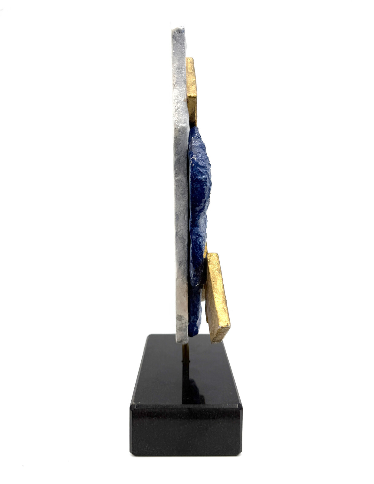 A sculptural composition featuring two stylized golden fish against a layered blue and white stone base.