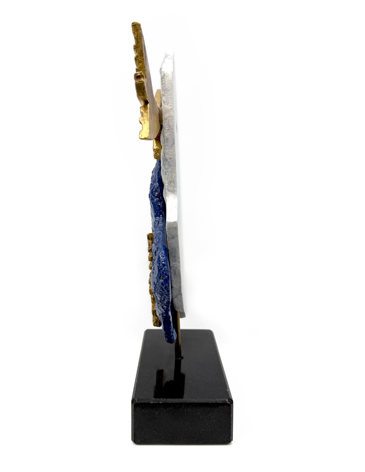 A sculptural composition featuring two stylized golden fish against a layered blue and white stone base.