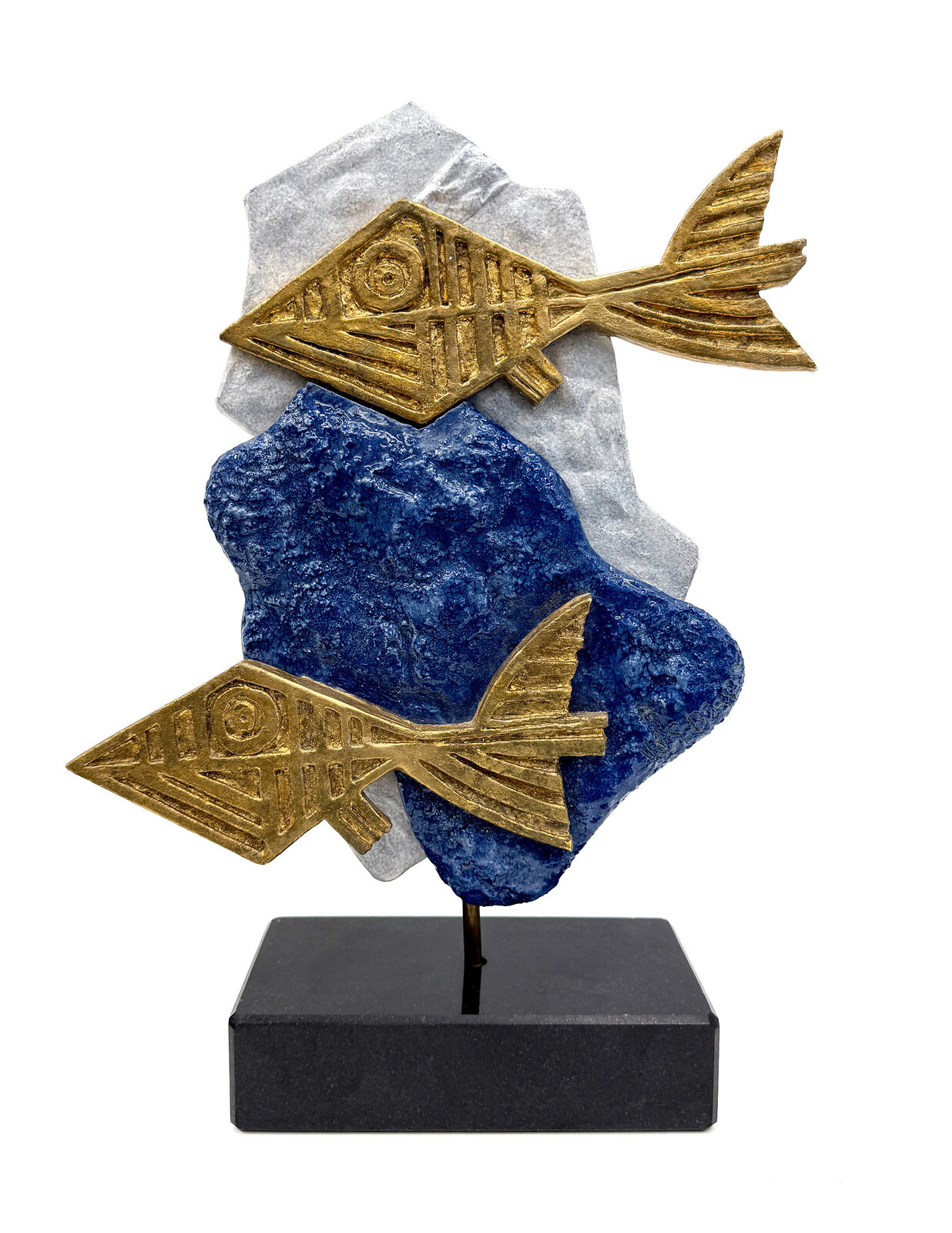A sculptural composition featuring two stylized golden fish against a layered blue and white stone base.