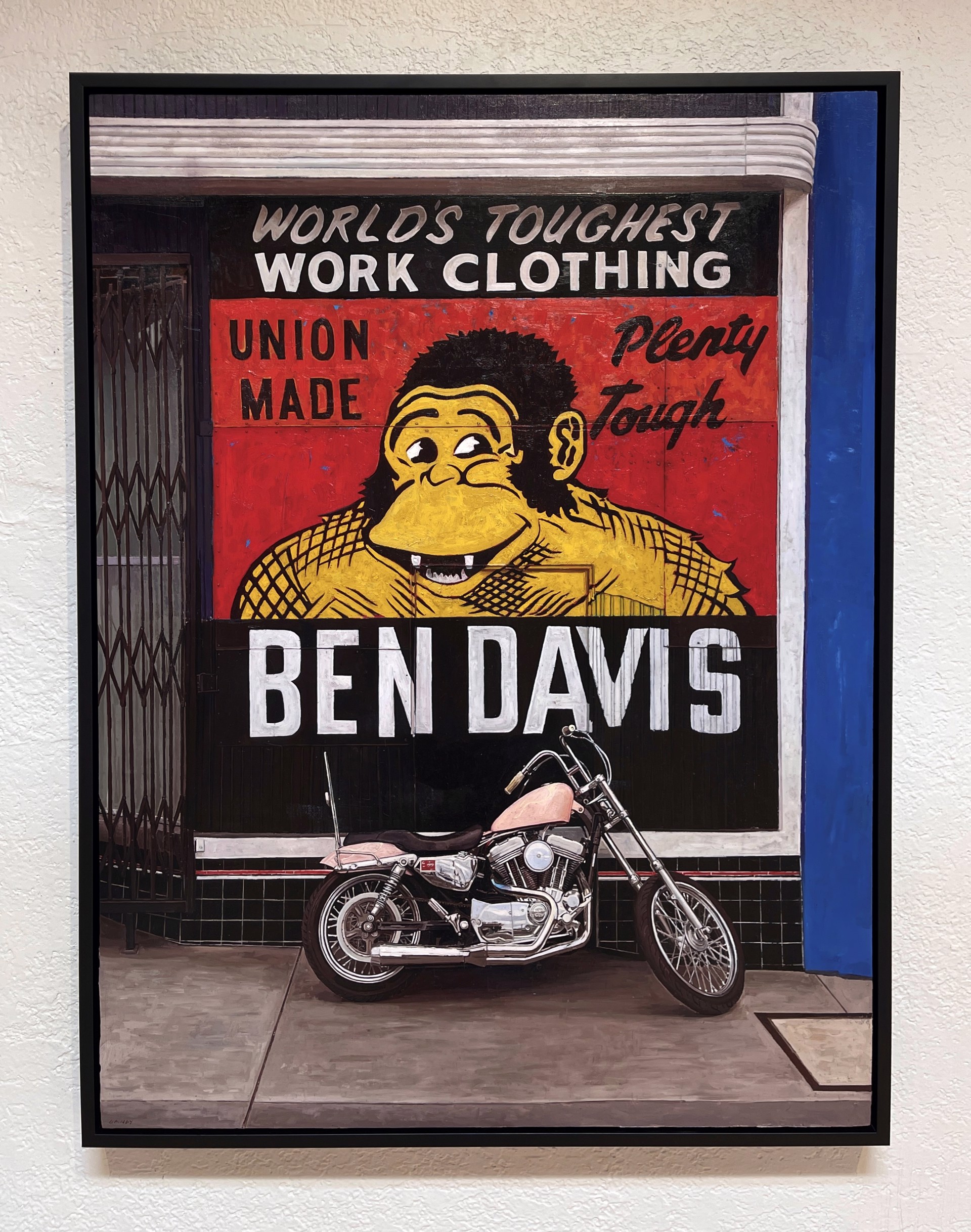 A motorcycle parked in front of a building with a sign on it.
