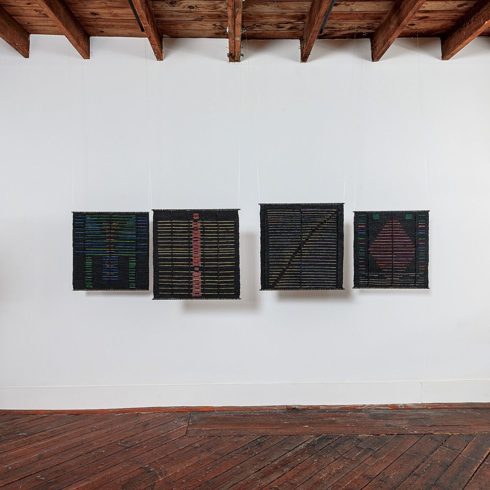 A woven textile featuring a central vertical motif of pink and red blocks against a dark background with horizontal yellow lines.