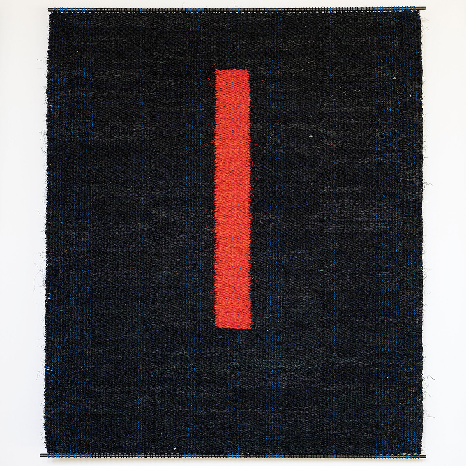 A woven textile featuring a bold red vertical stripe against a dark textured background.