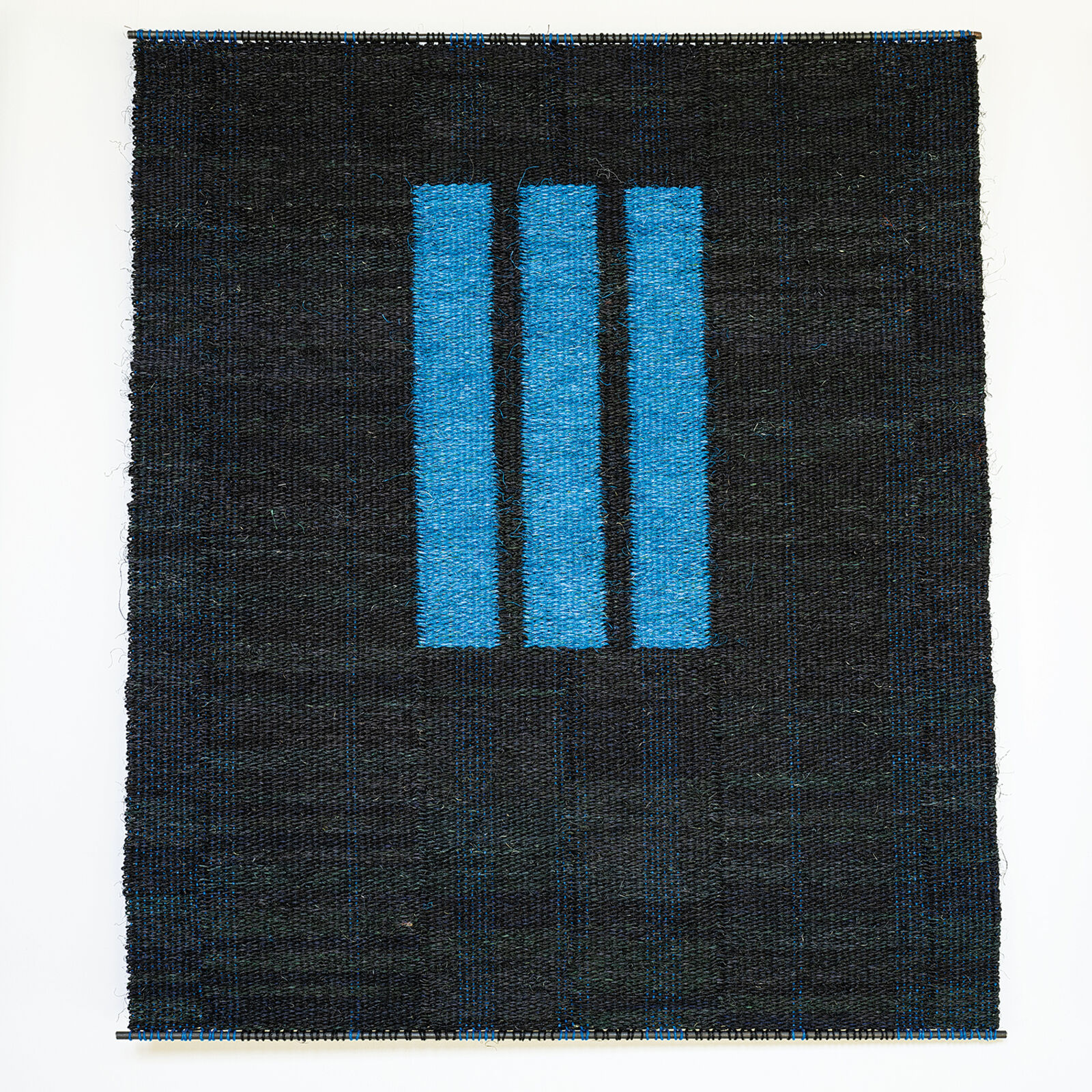 A woven textile featuring three vertical blue stripes against a dark, textured background.
