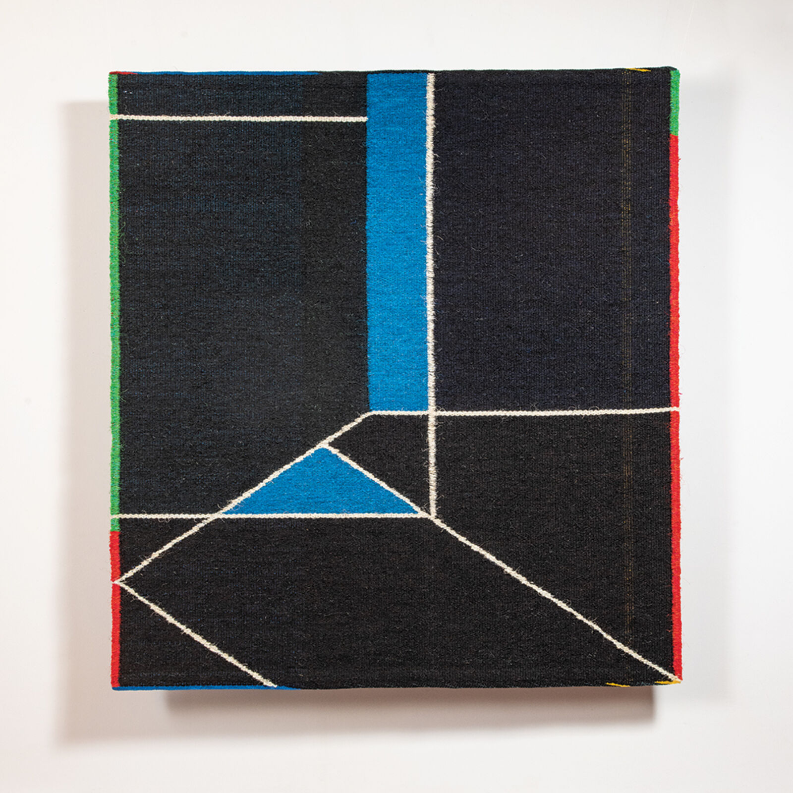 A geometric textile artwork featuring a black canvas with white lines and blue triangles.