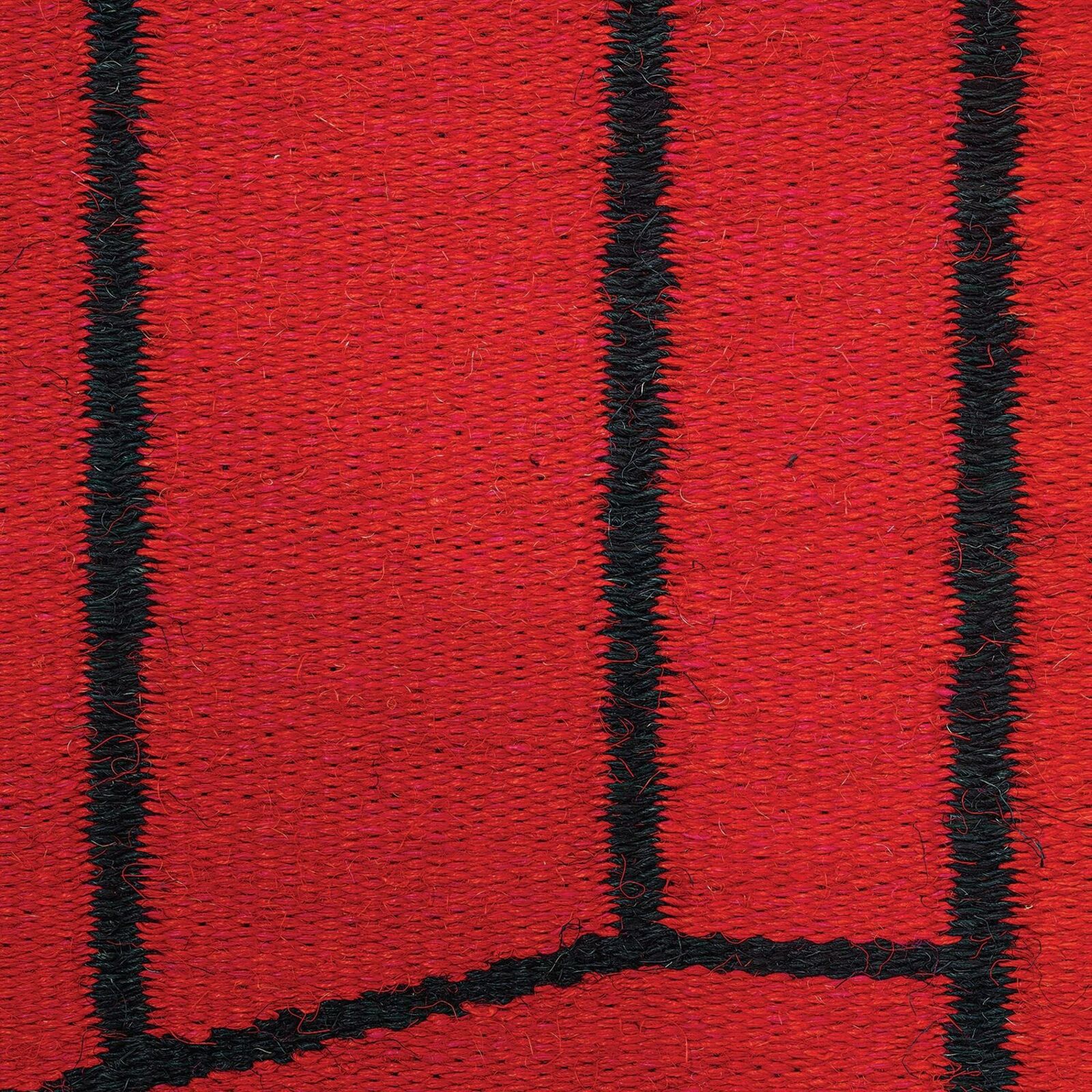 A bold red textile artwork featuring black geometric lines displayed in a gallery space.