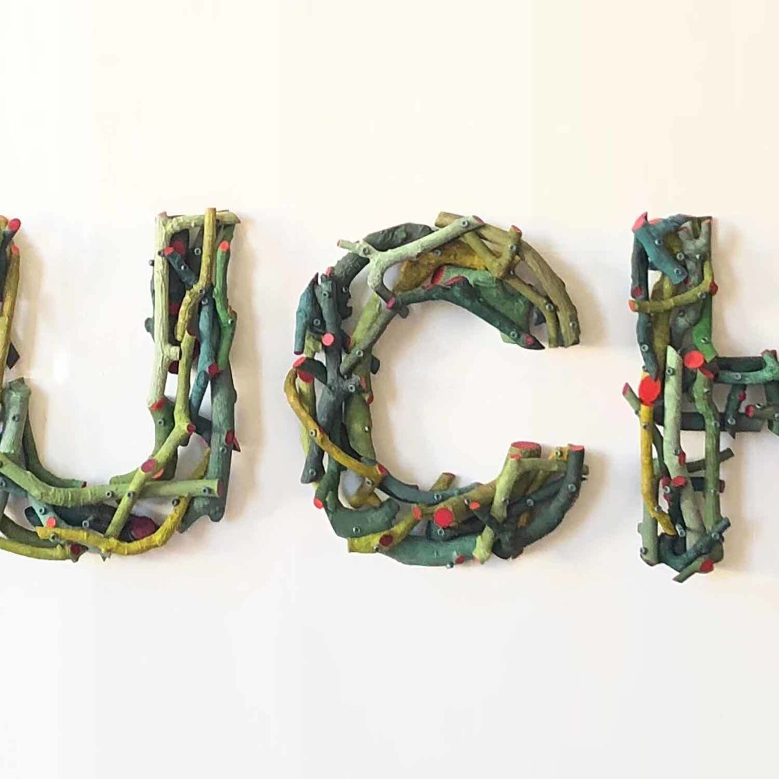 A sign that says Ouch! on a white wall. 