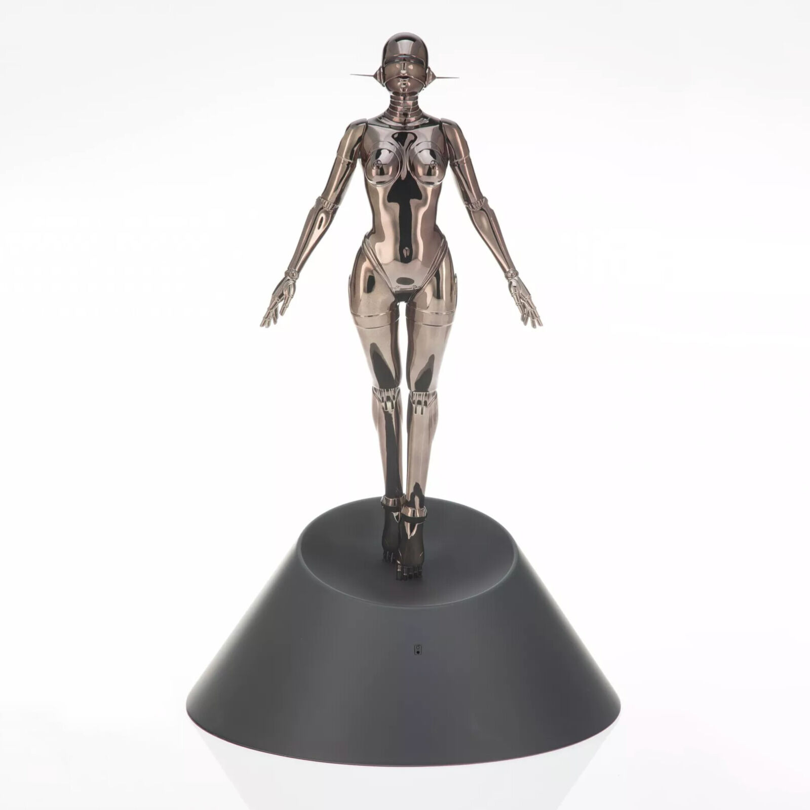 A metal sculpture of a woman standing on a black base.