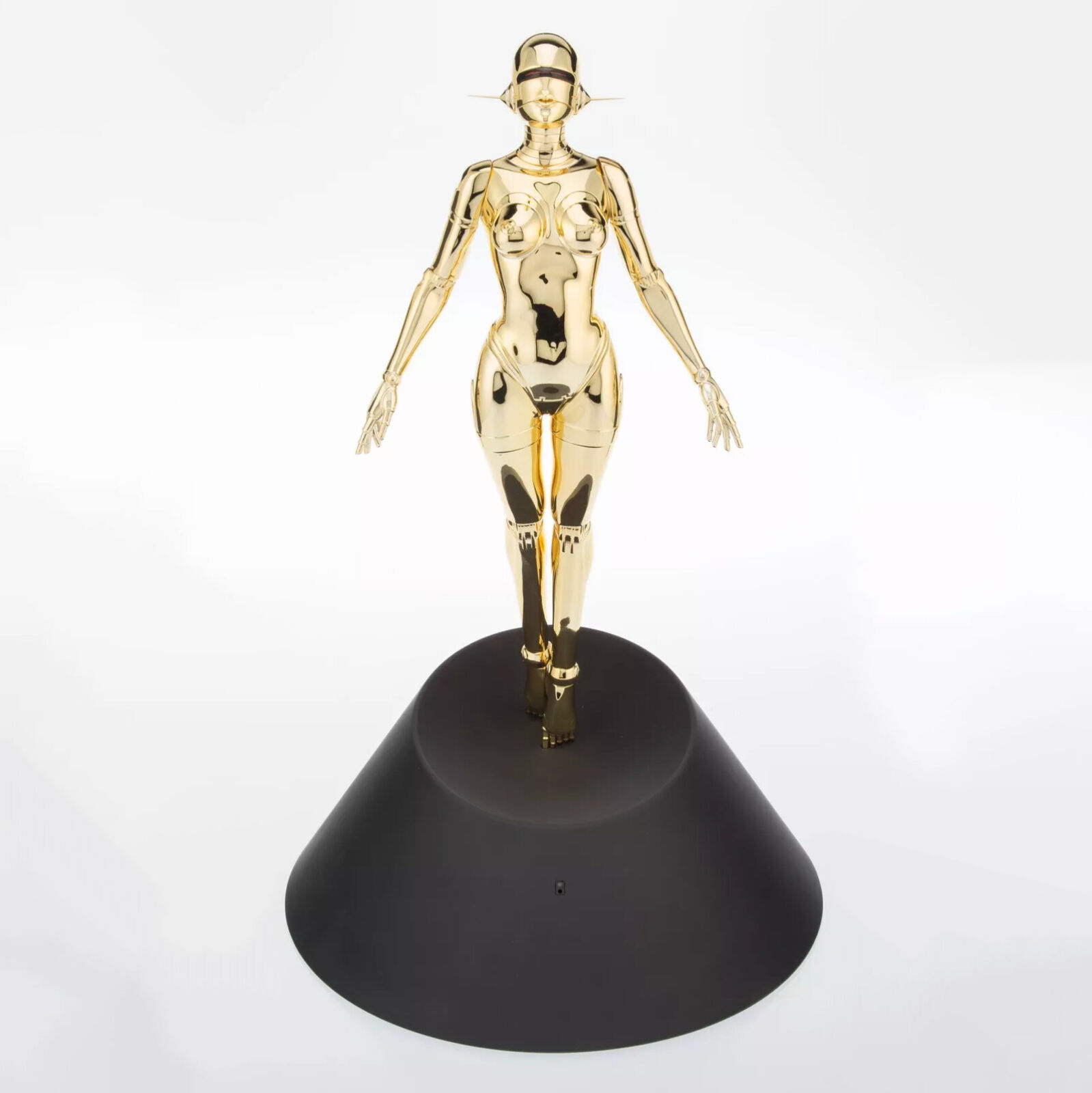 A gold statue of a woman standing on a black base.