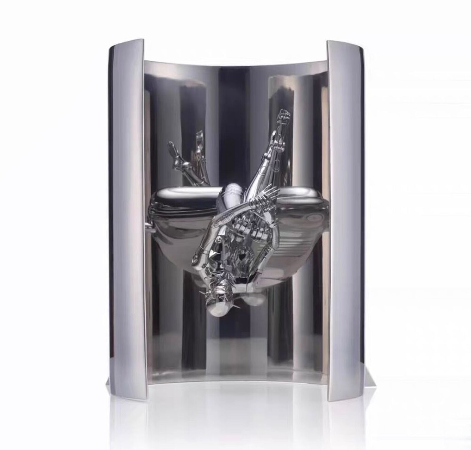 A silver sculpture of a man sitting on top of a toilet.