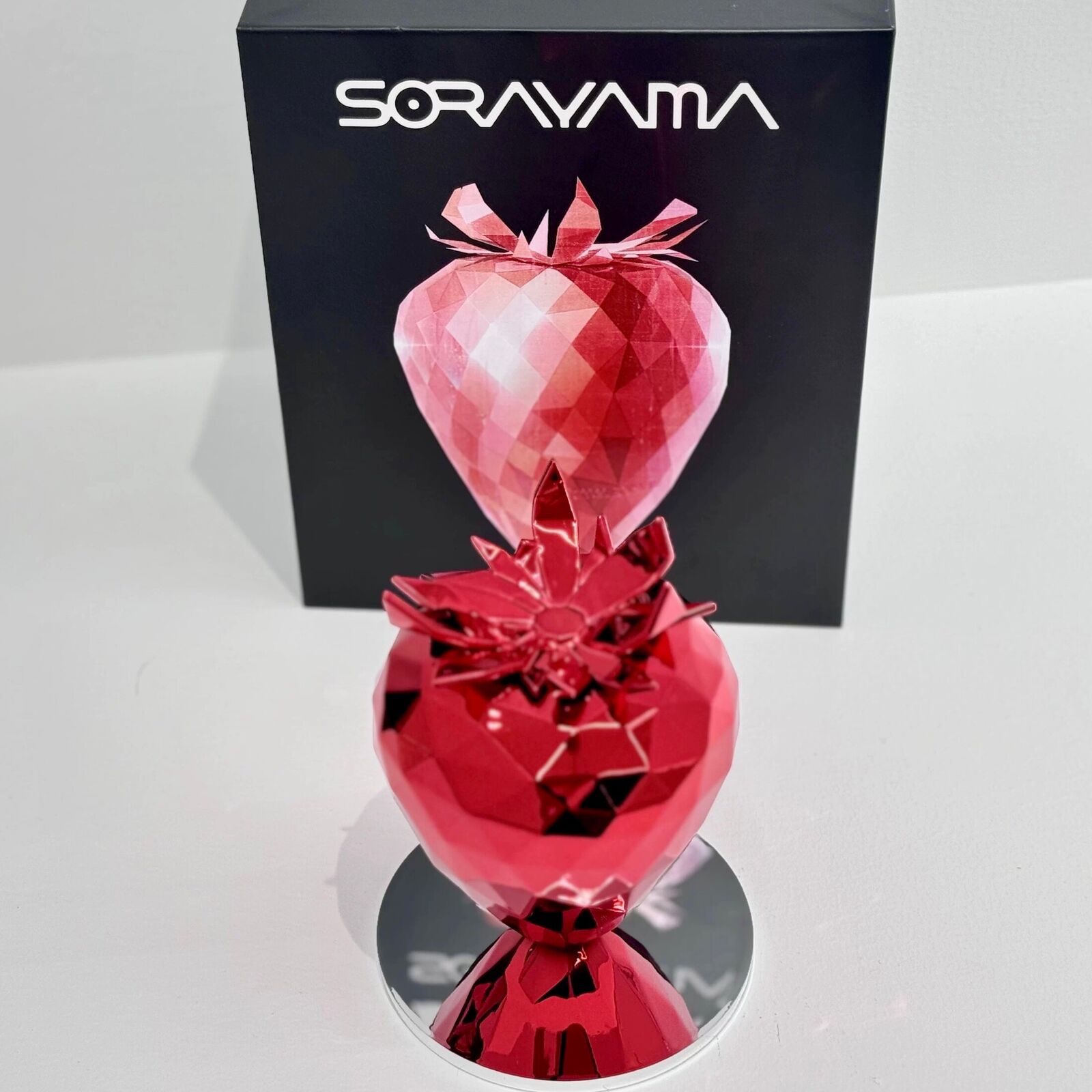 A red heart shaped object on a white background.