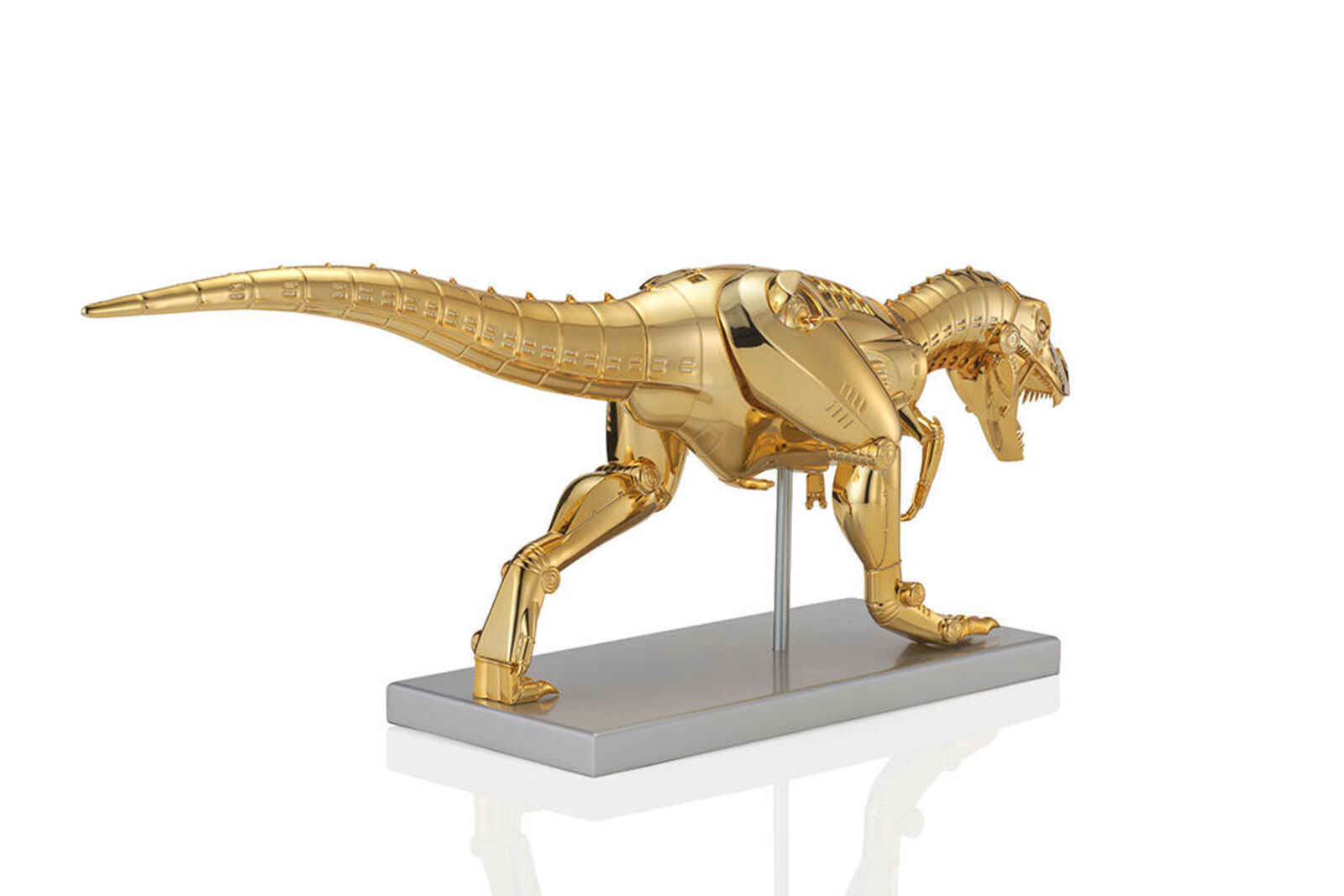 A gold model of a t-rex on a white background.
