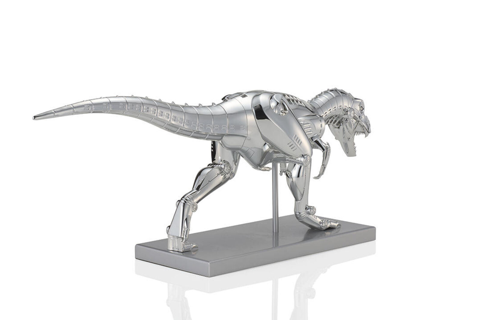 A metal model of a t-rex on a white background.