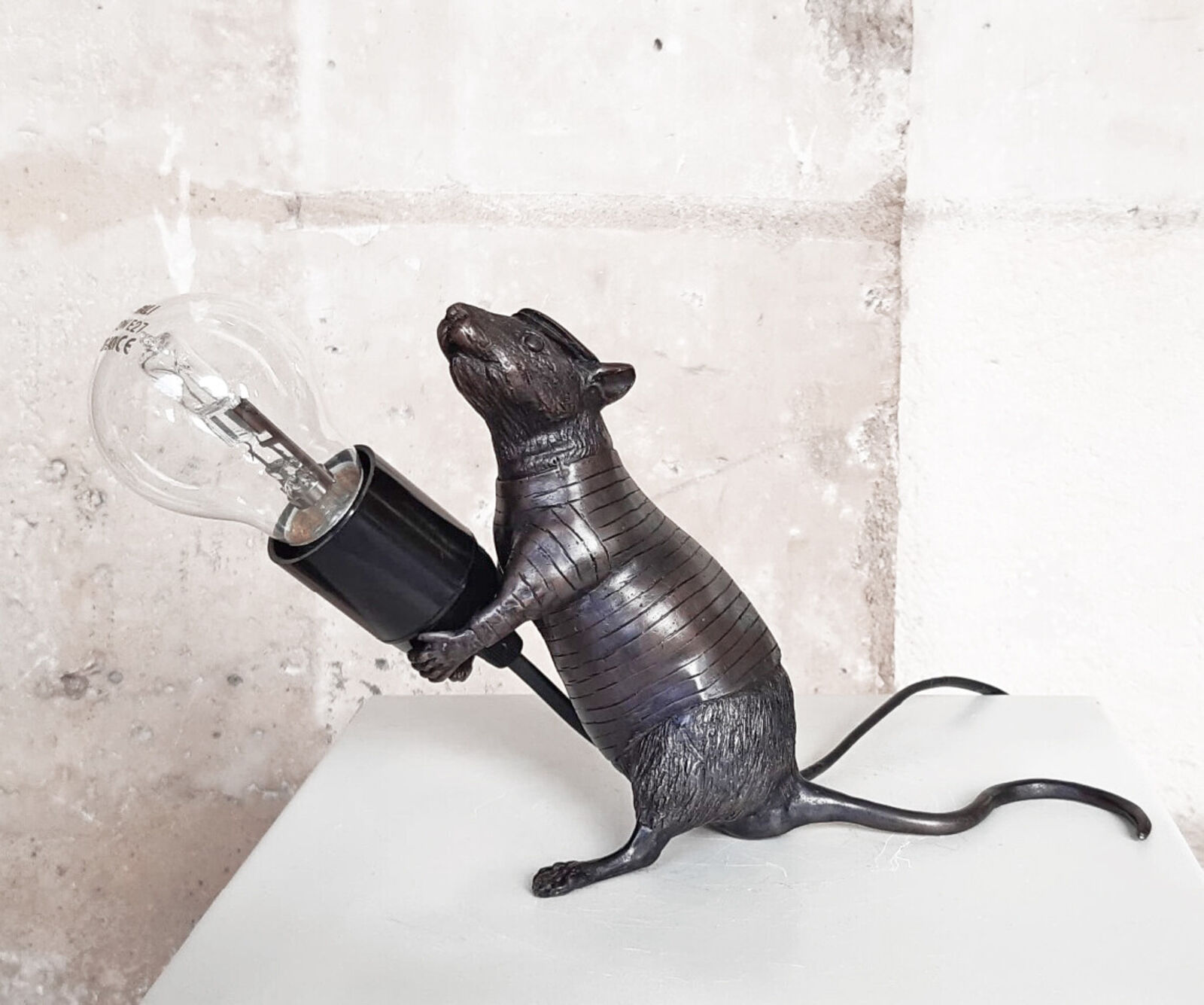 A rat lamp with a light bulb on top of it.