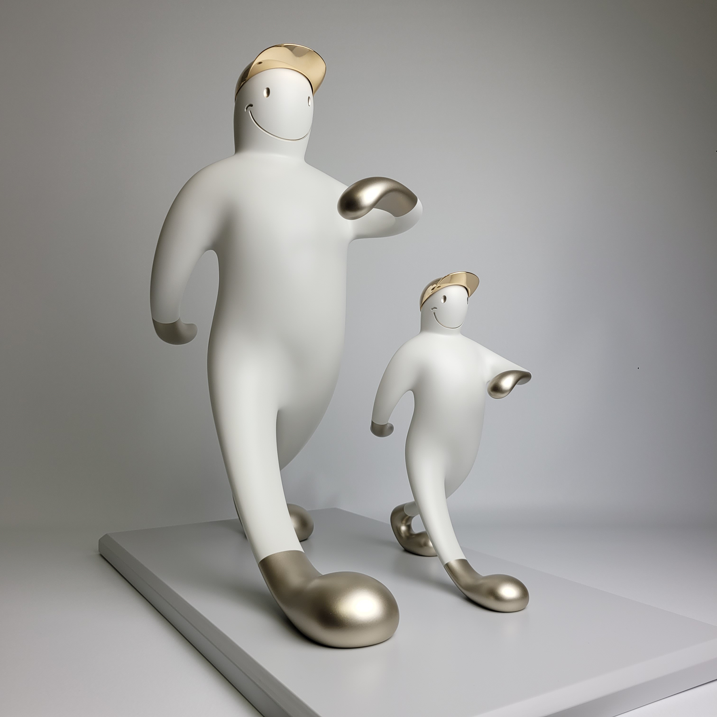 A playful sculpture of two figures in a matching pose, featuring smooth white forms with metallic accents.
