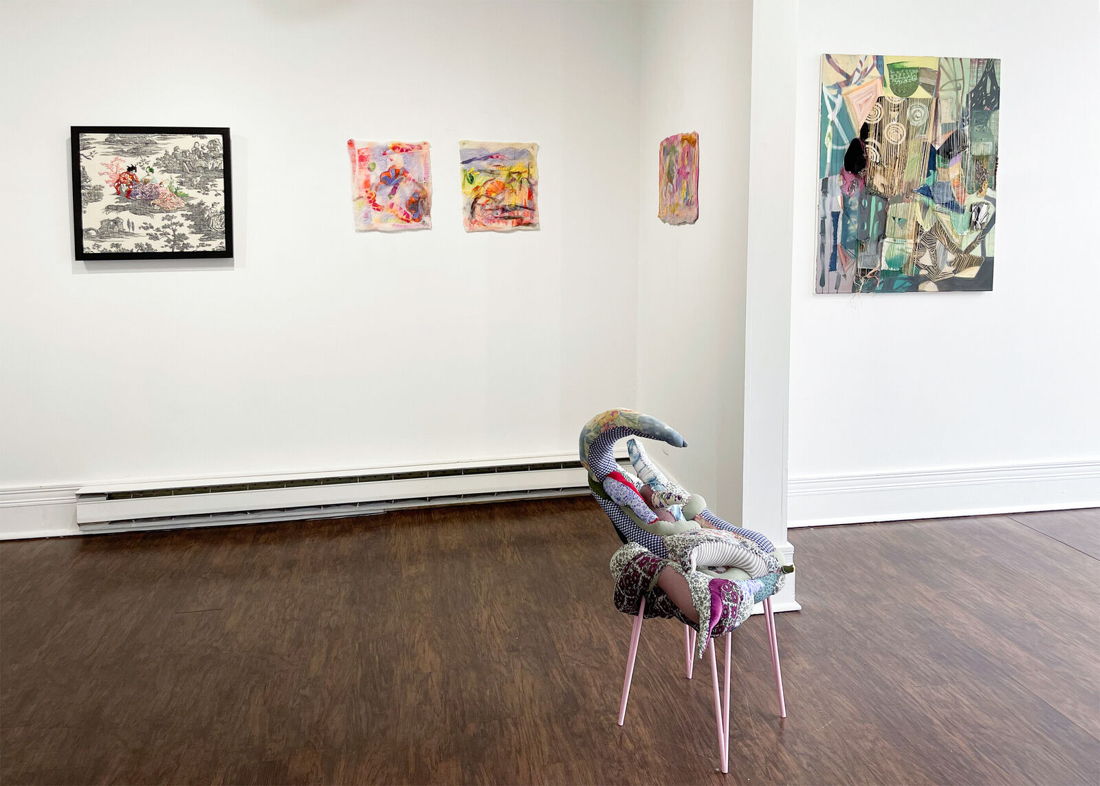 A whimsical chair with a patchwork quilt seat and slender pink legs.