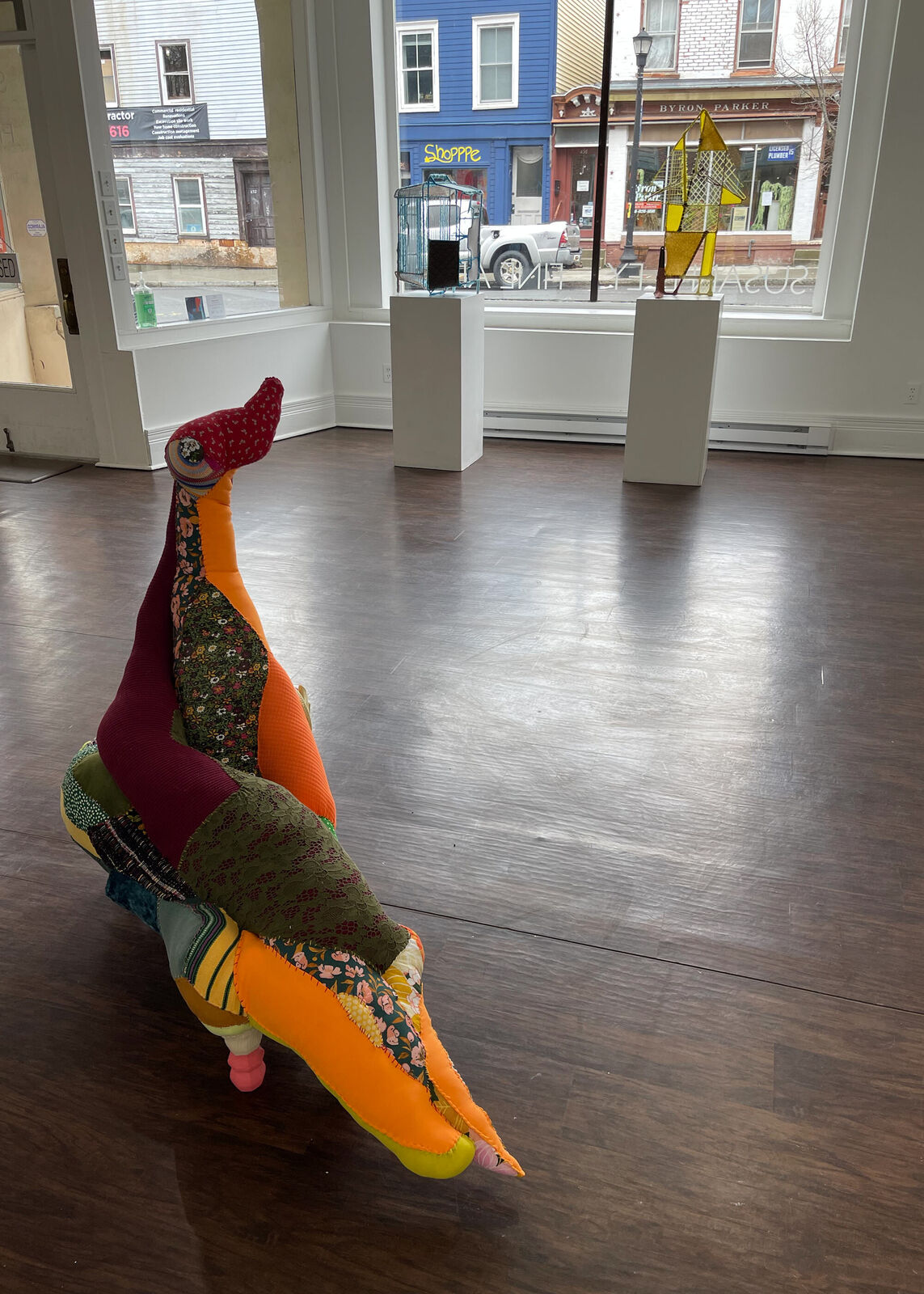 A colorful, patchwork-style lounge chair shaped like a reclining figure with an upward-extended leg.