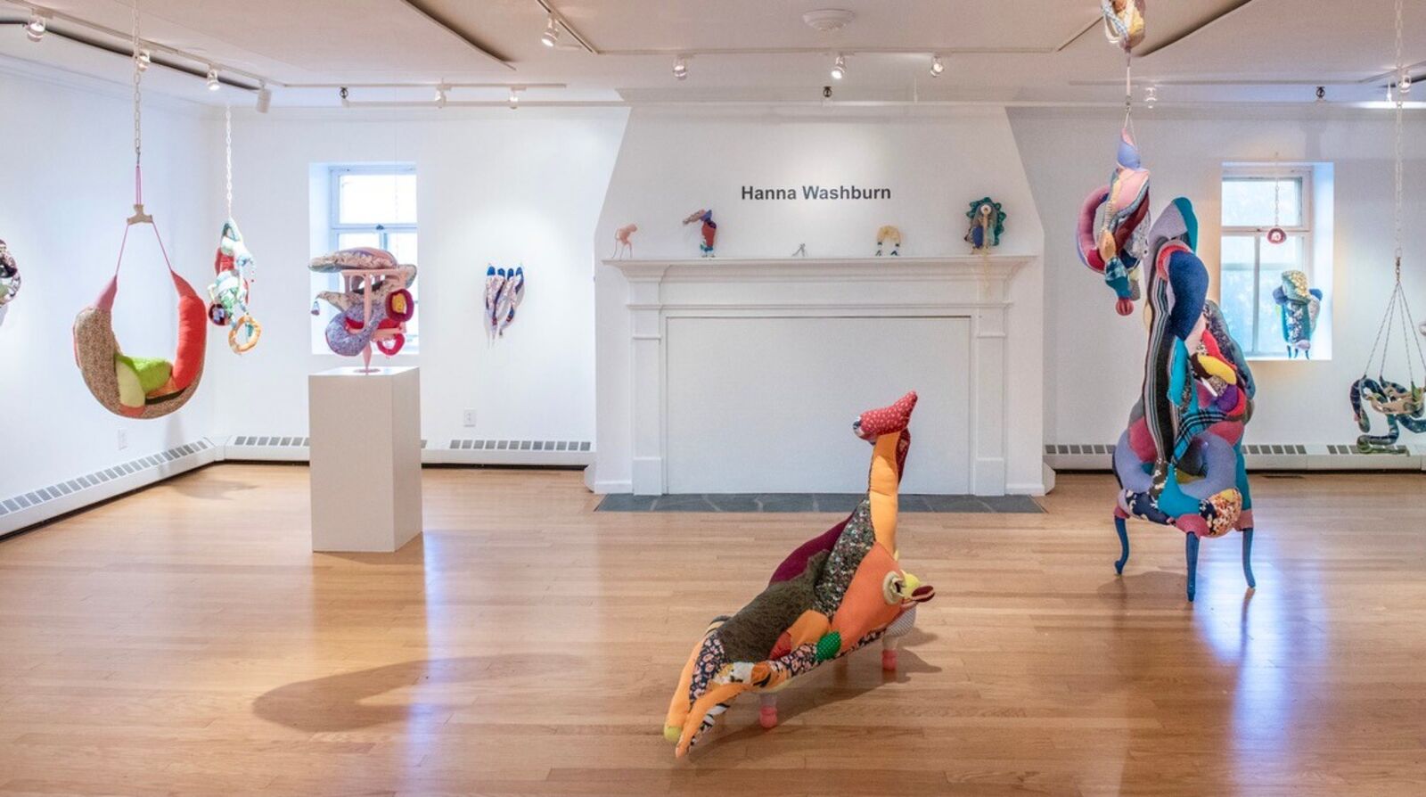 A colorful, patchwork-style lounge chair shaped like a reclining figure with an upward-extended leg.