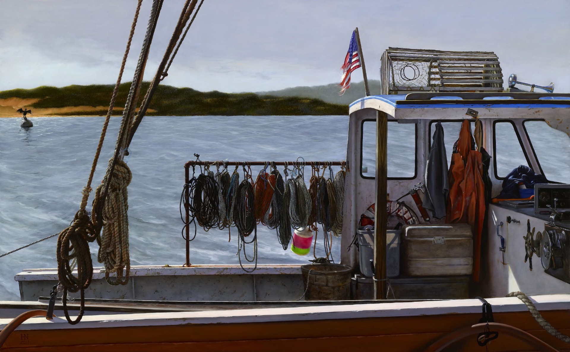 A weathered fishing boat deck filled with hanging nets and ropes against a calm sea.