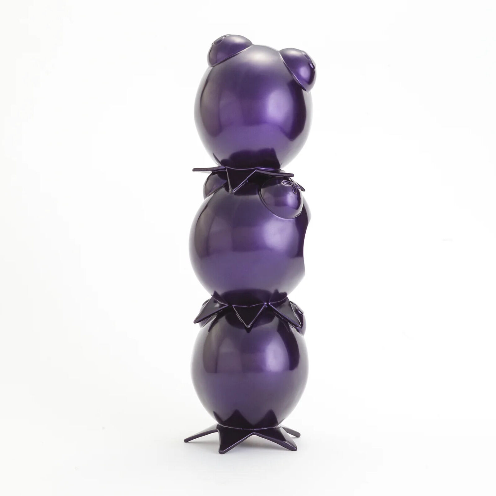 A stack of three purple ceramic figurines on a white background.