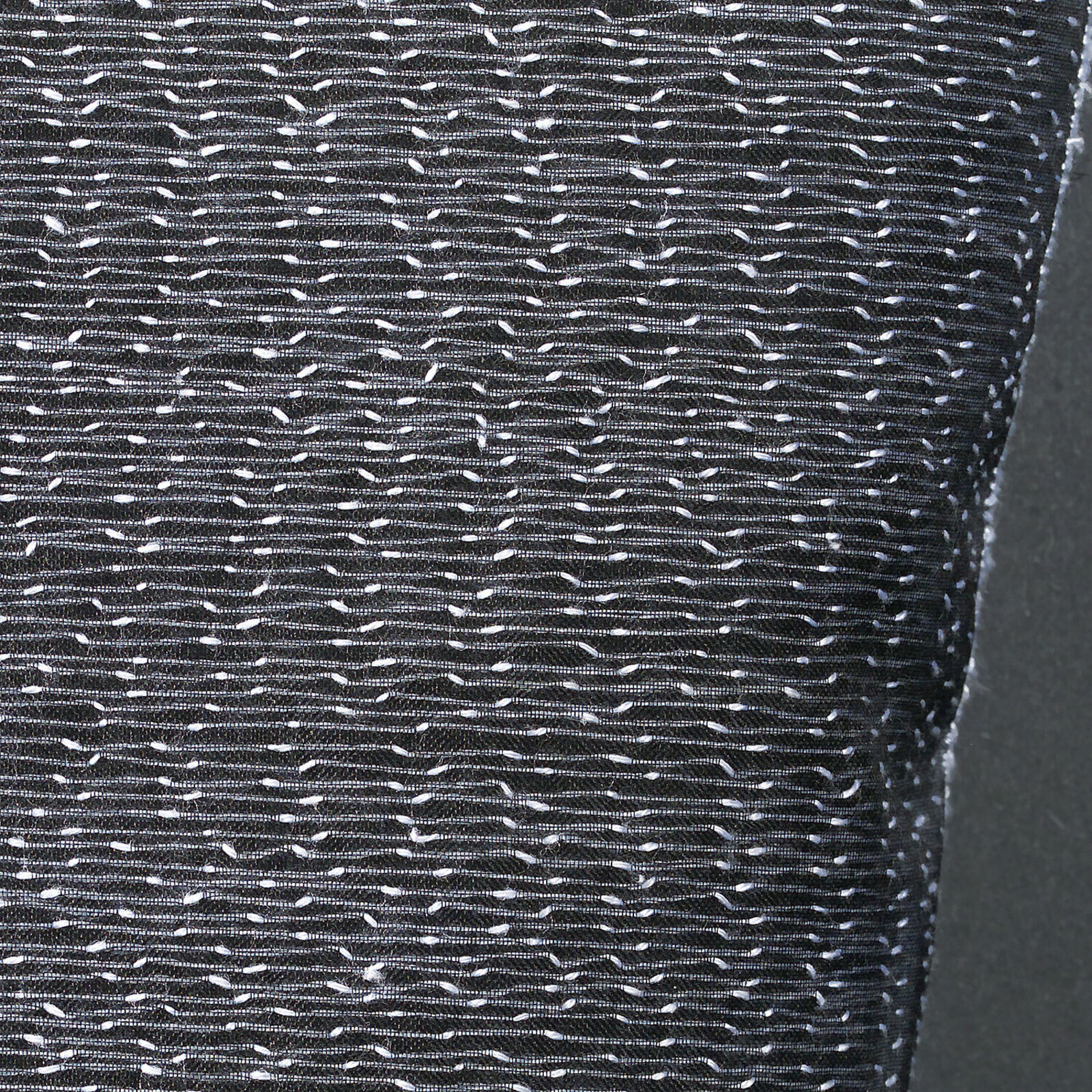 A framed textile grid of grey woven cups on a white wall.