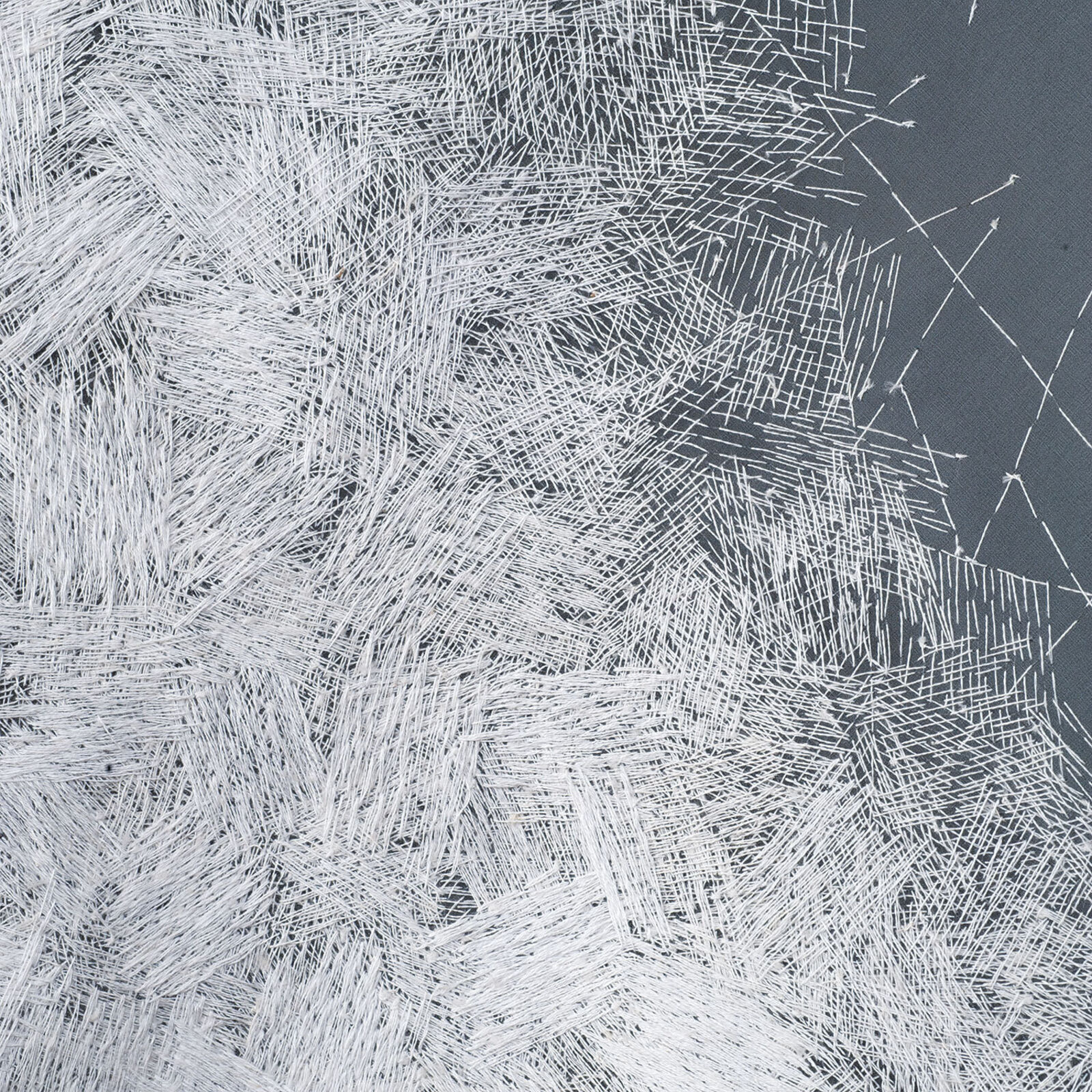 A minimalist textile sculpture featuring a folded triangular form with contrasting textures.
