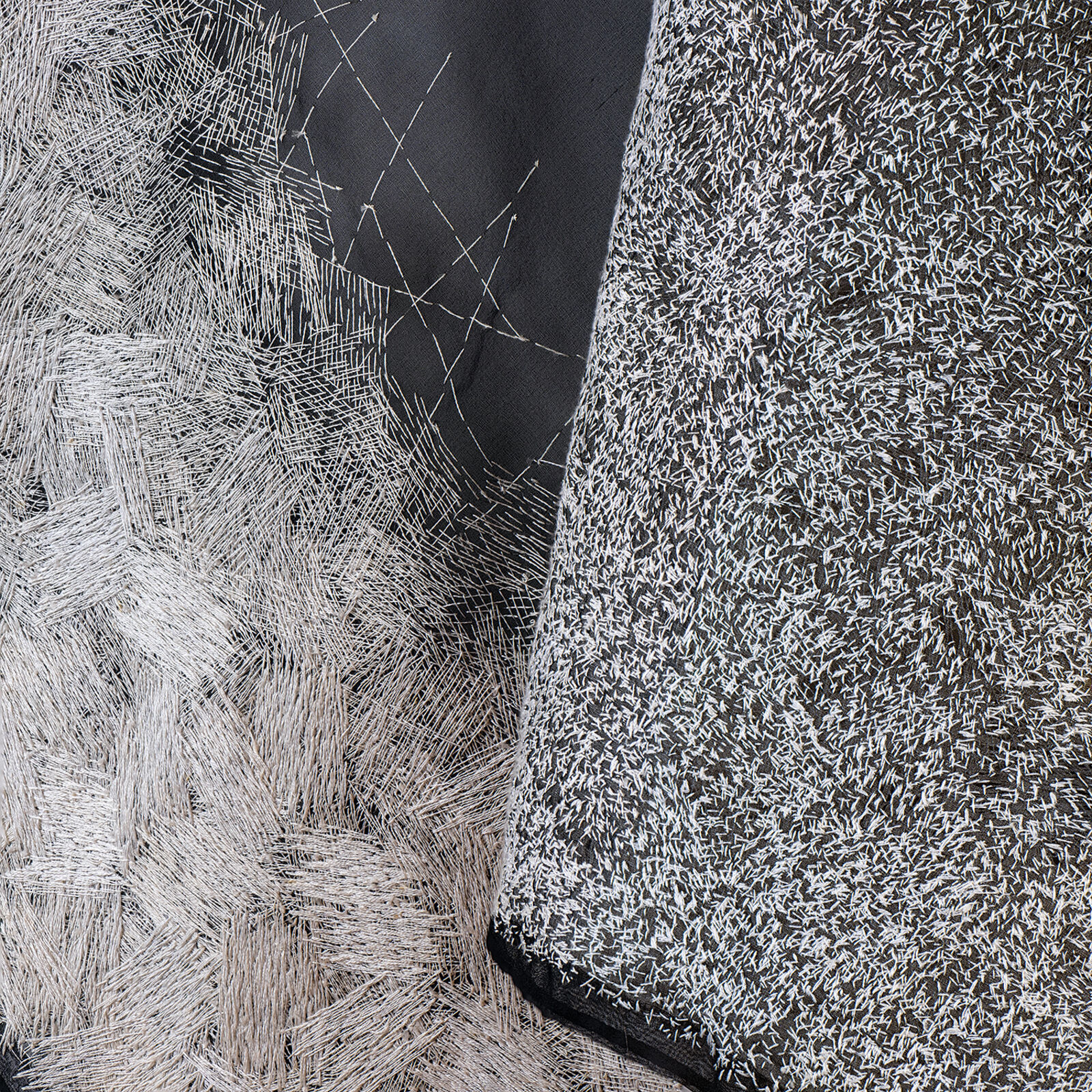 A minimalist textile sculpture featuring a folded triangular form with contrasting textures.