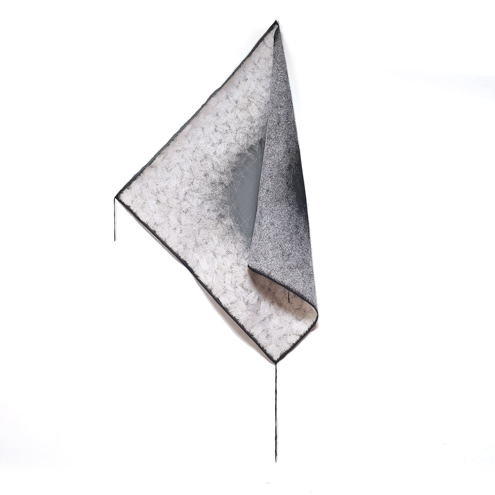 A minimalist textile sculpture featuring a folded triangular form with contrasting textures.