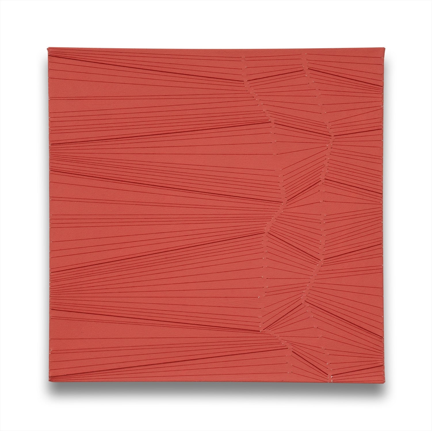 A red wall hanging on a white wall. 