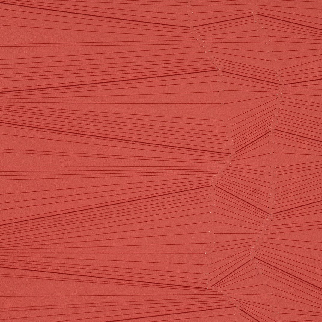 A red wall hanging on a white wall. 