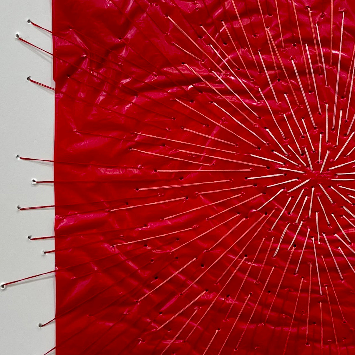 A picture of a red piece of art in a white frame.