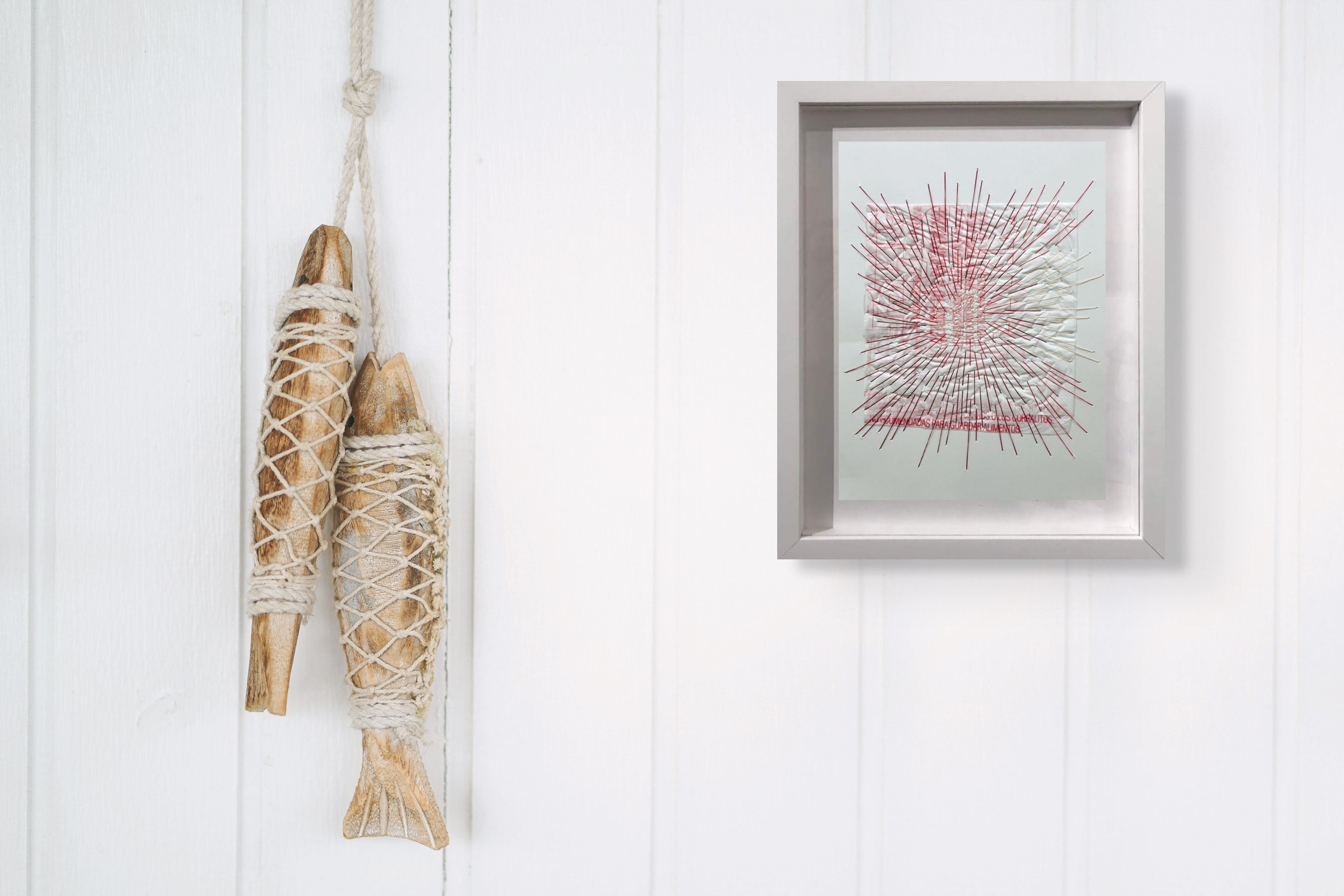 A picture of a white frame with a red and white drawing on it.