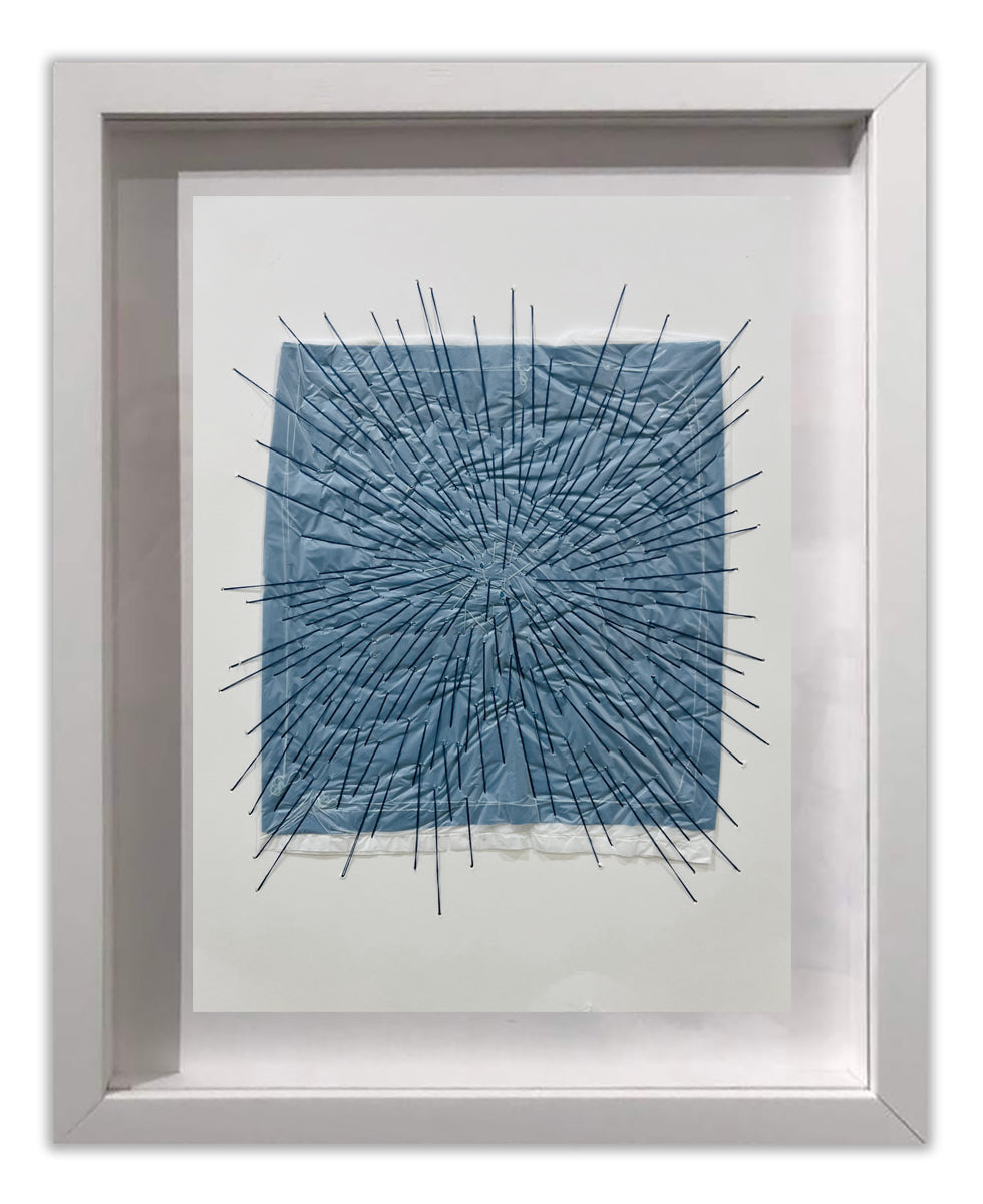 A picture of a blue and white abstract painting in a white frame.