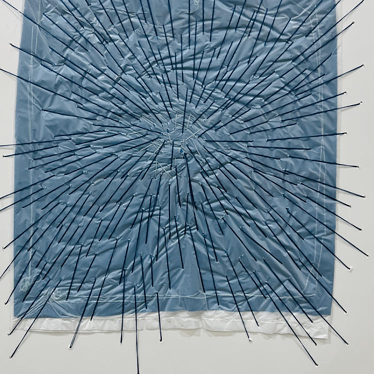 A picture of a blue and white abstract painting in a white frame.