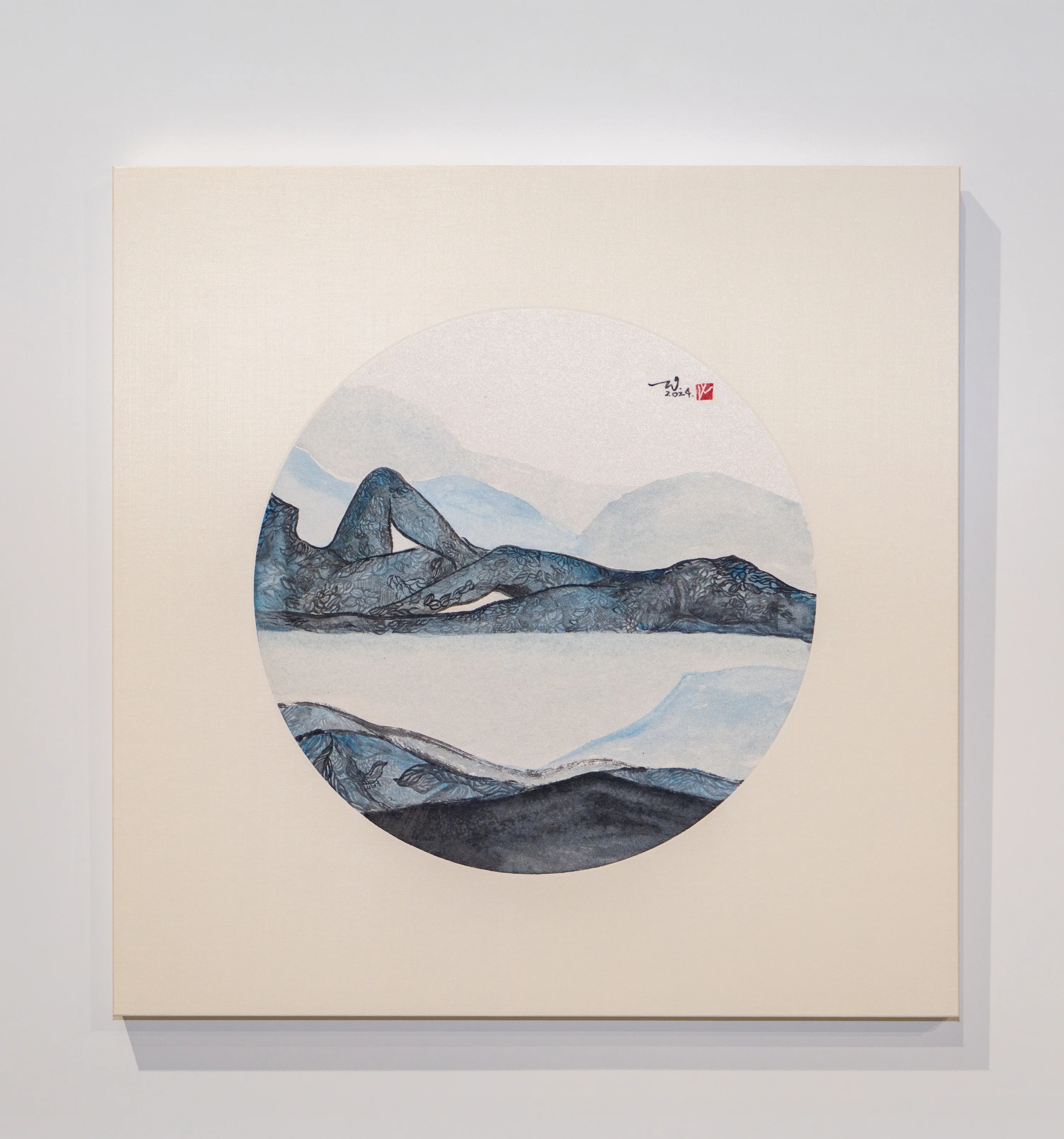 A minimalist gallery scene featuring a square painting with a circular landscape motif.