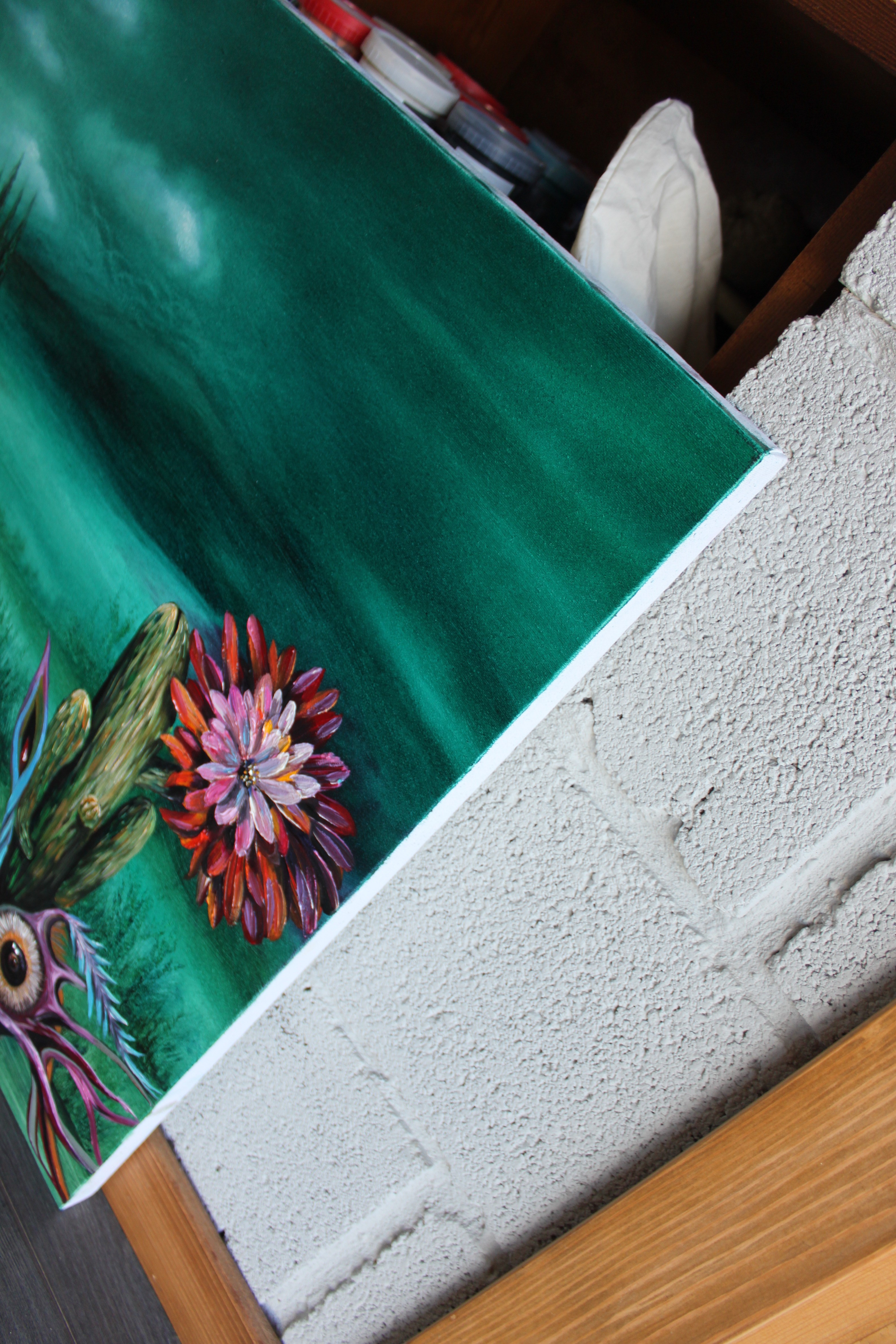 A painting of a cactus with a flower on it.